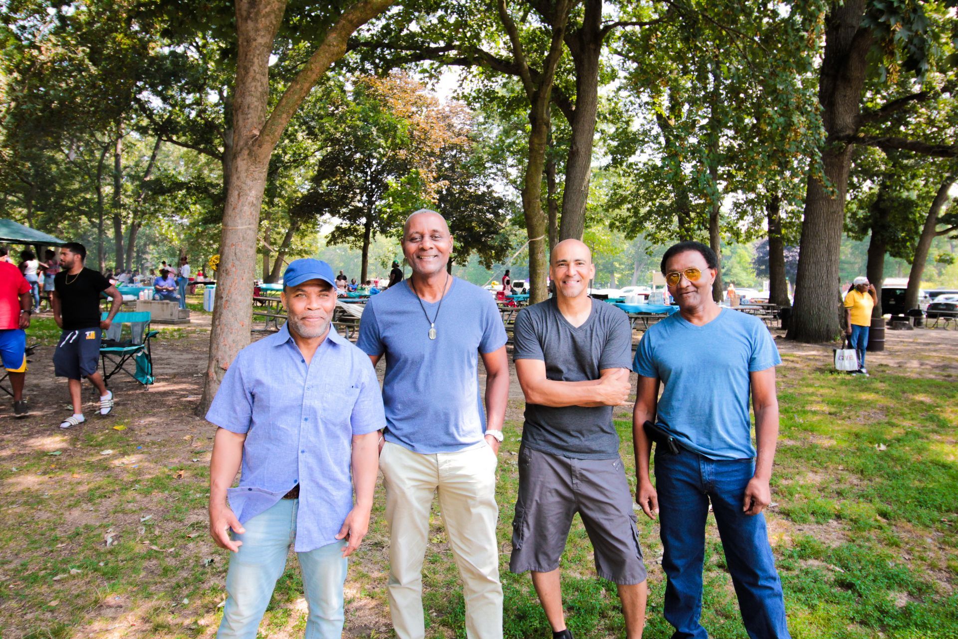 A group of men are posing for a picture in a park.