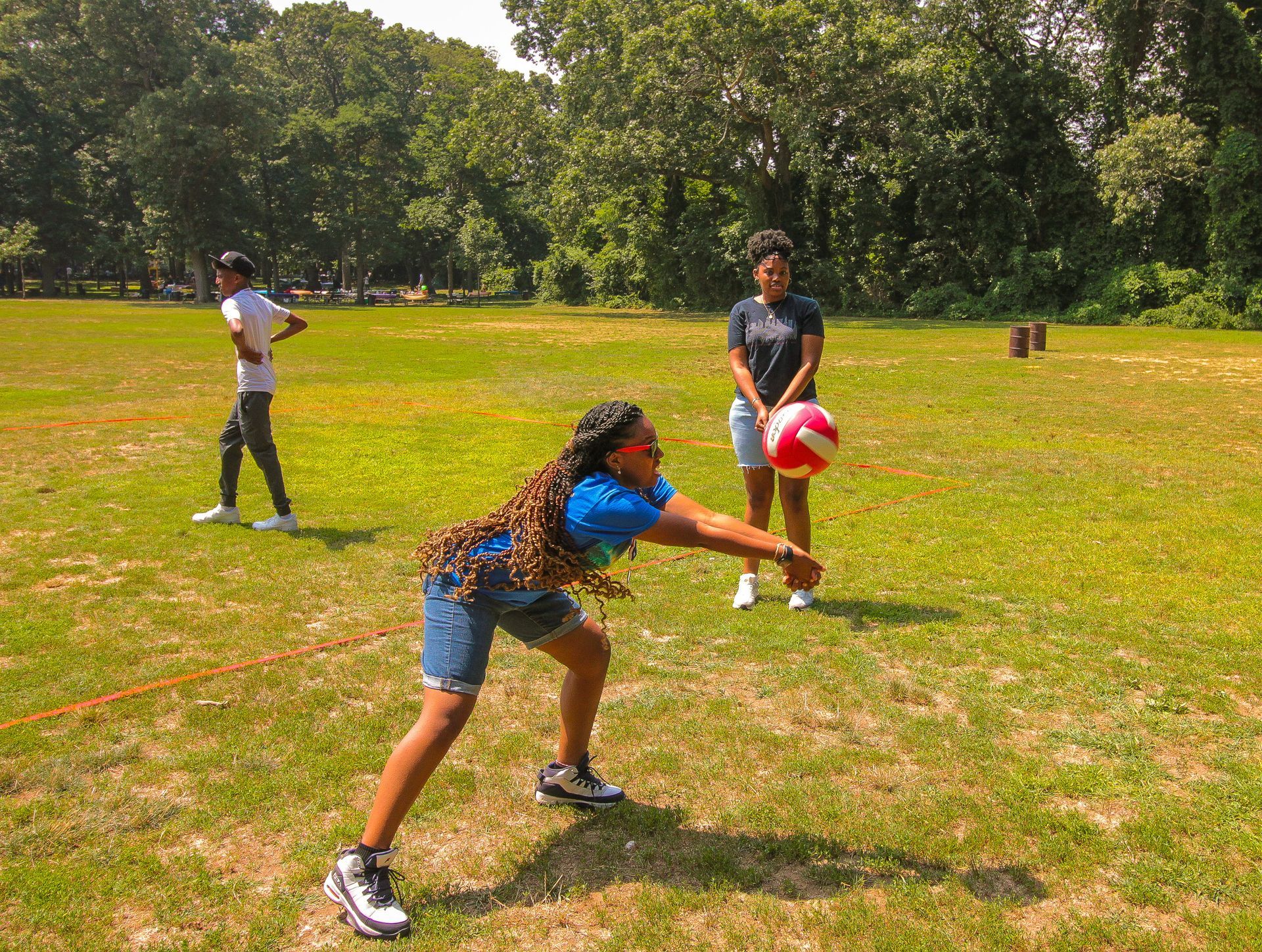 A group of children are playing volleyball in a field.