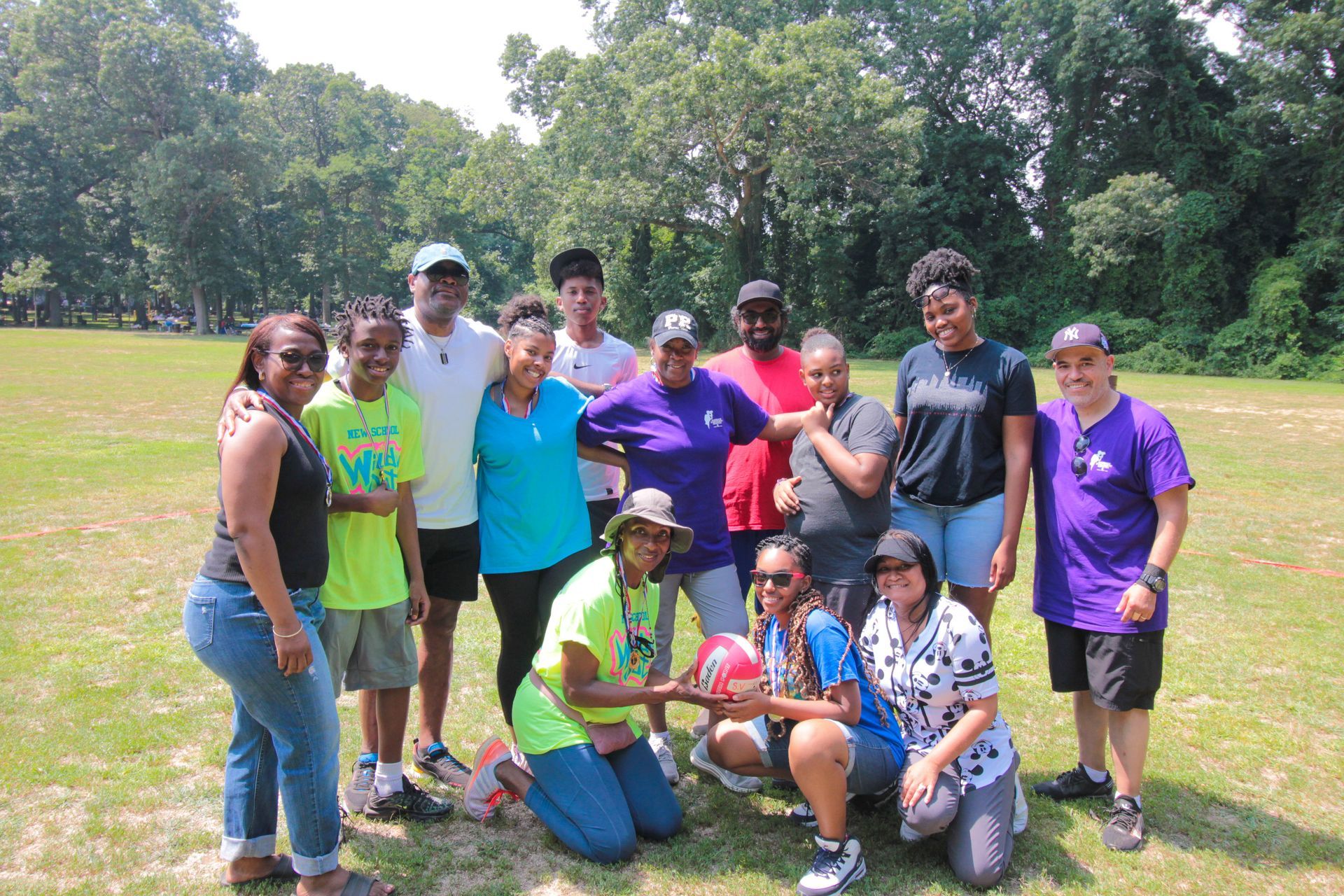 A group of people are posing for a picture in a field.
