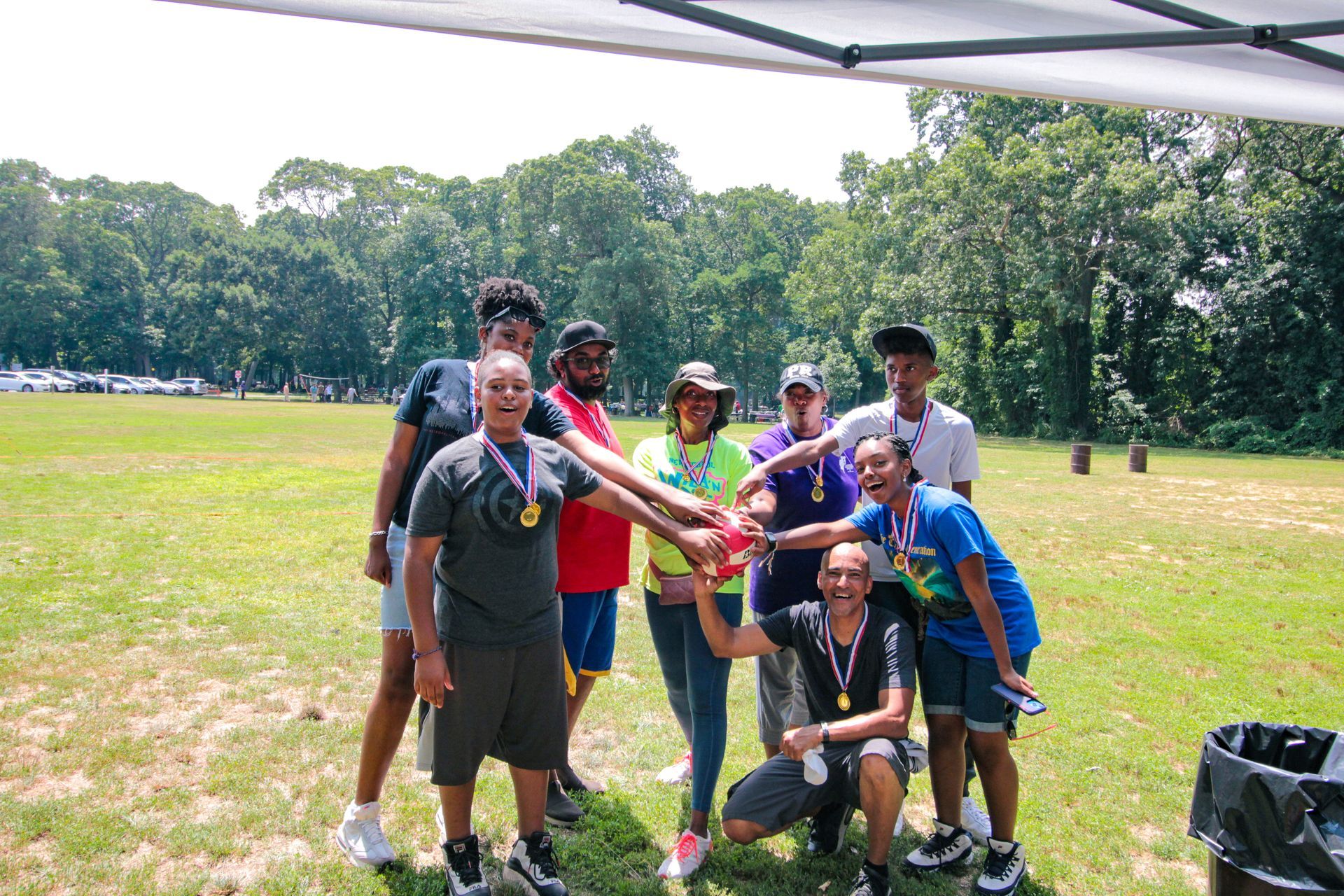 A group of people are posing for a picture in a field.