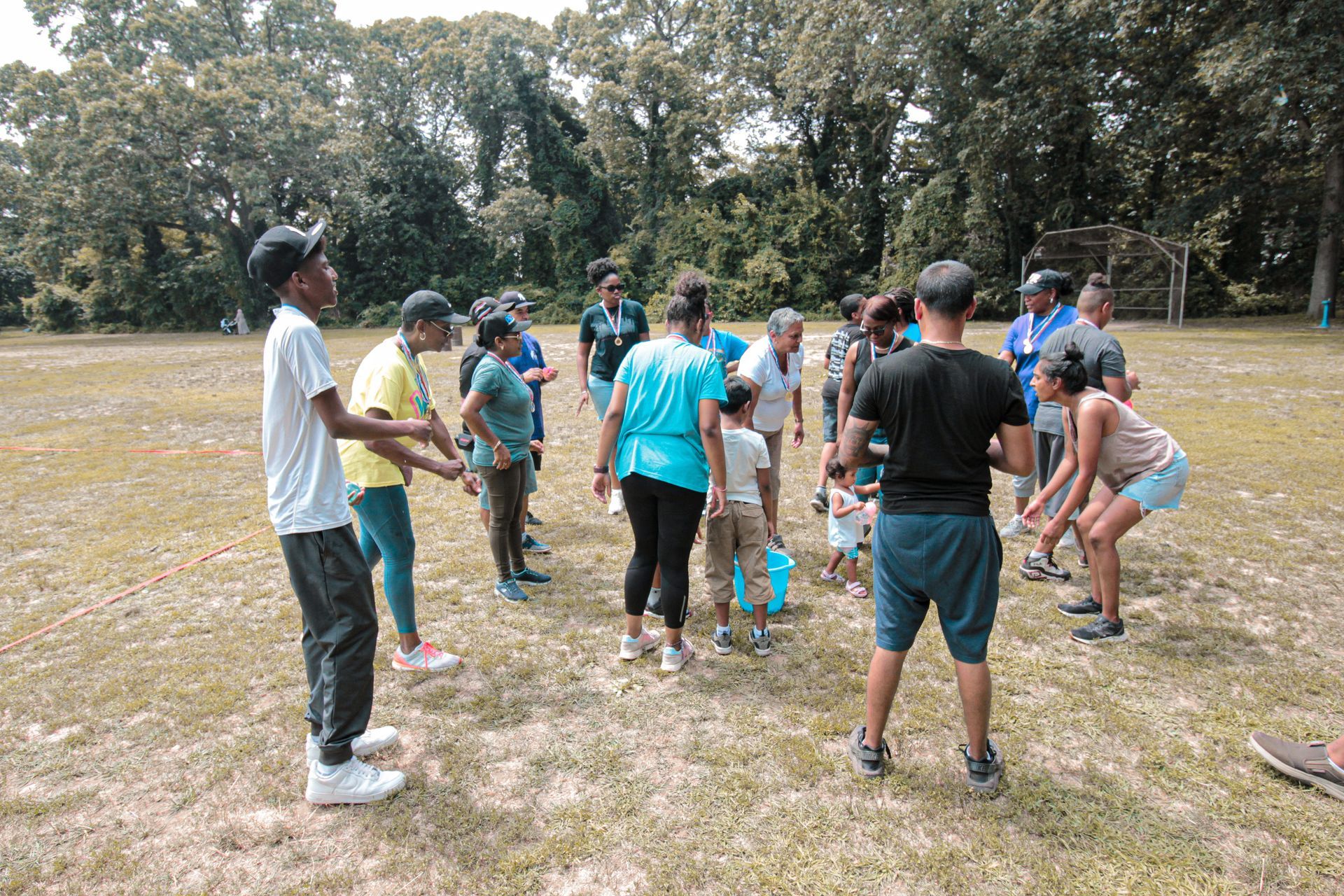 A group of people are standing in a circle in a field.