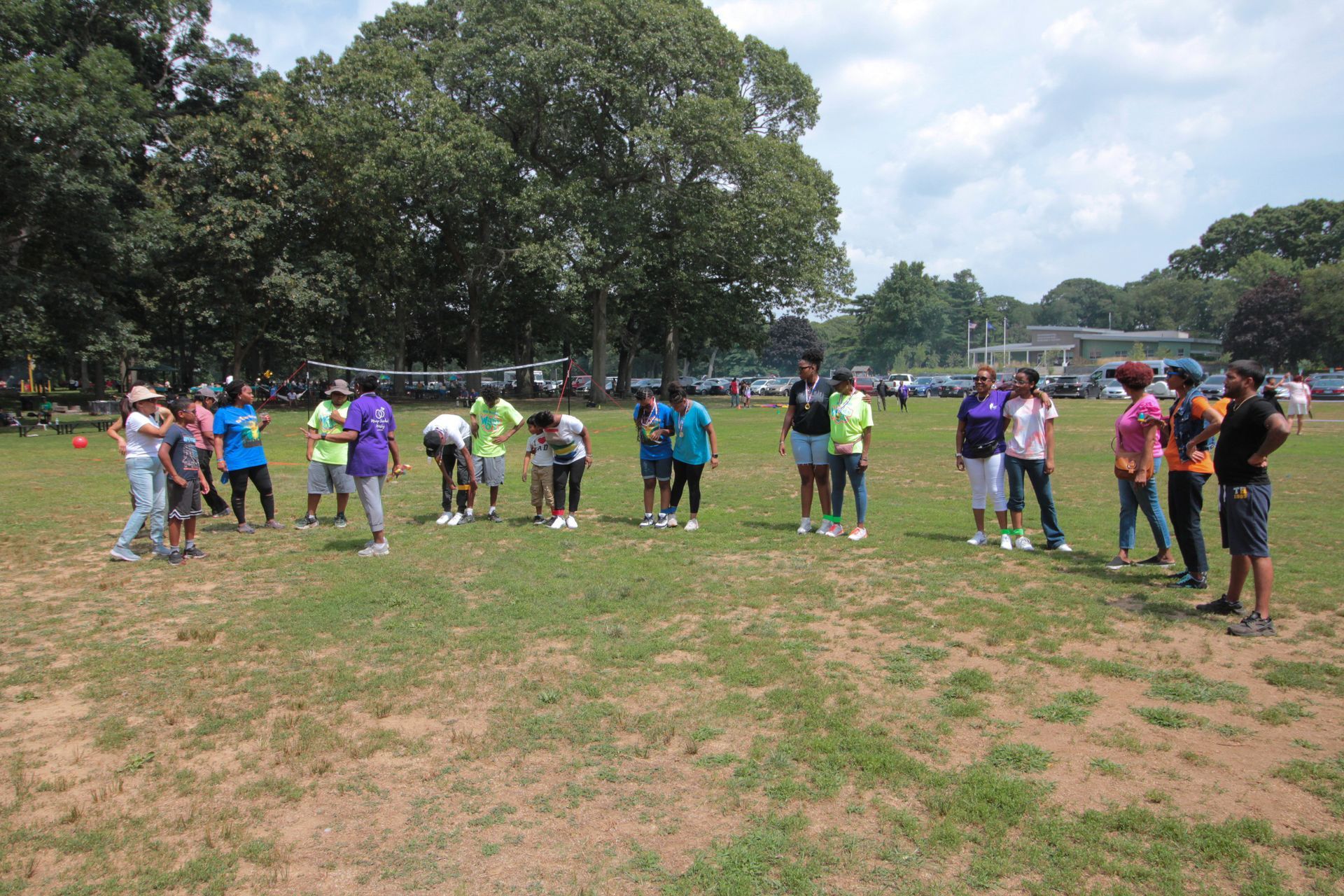 A group of people standing in a field with trees in the background