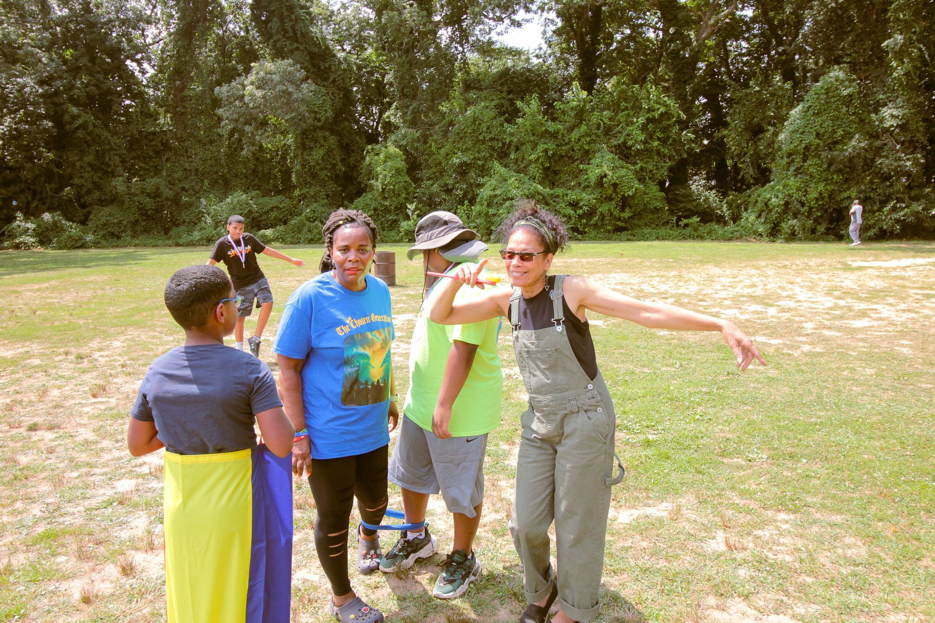 A group of people are standing in a grassy field.