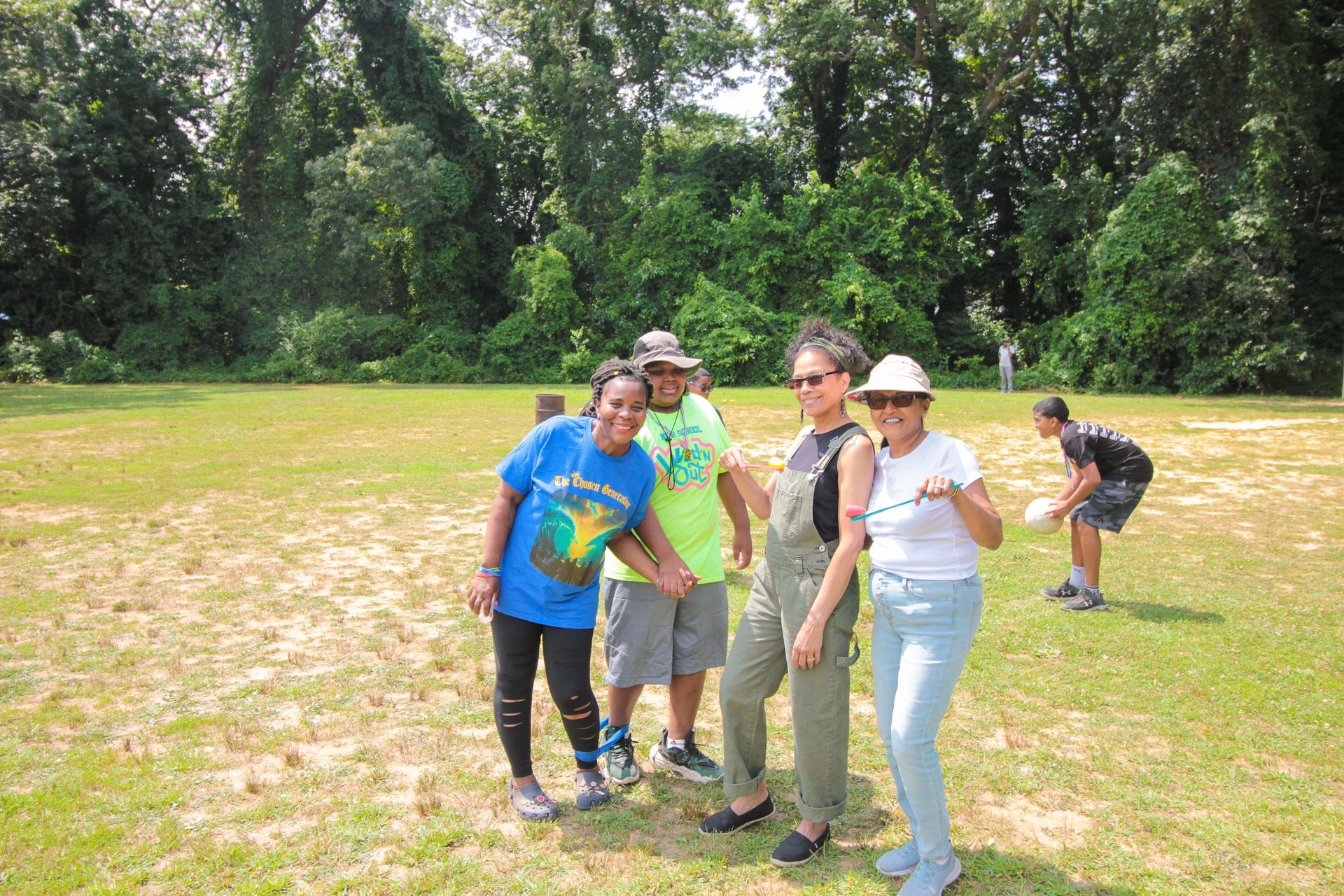 A group of people are posing for a picture in a field.