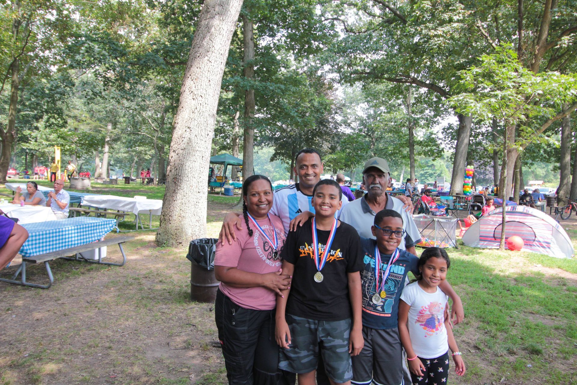 A group of people are posing for a picture in a park.