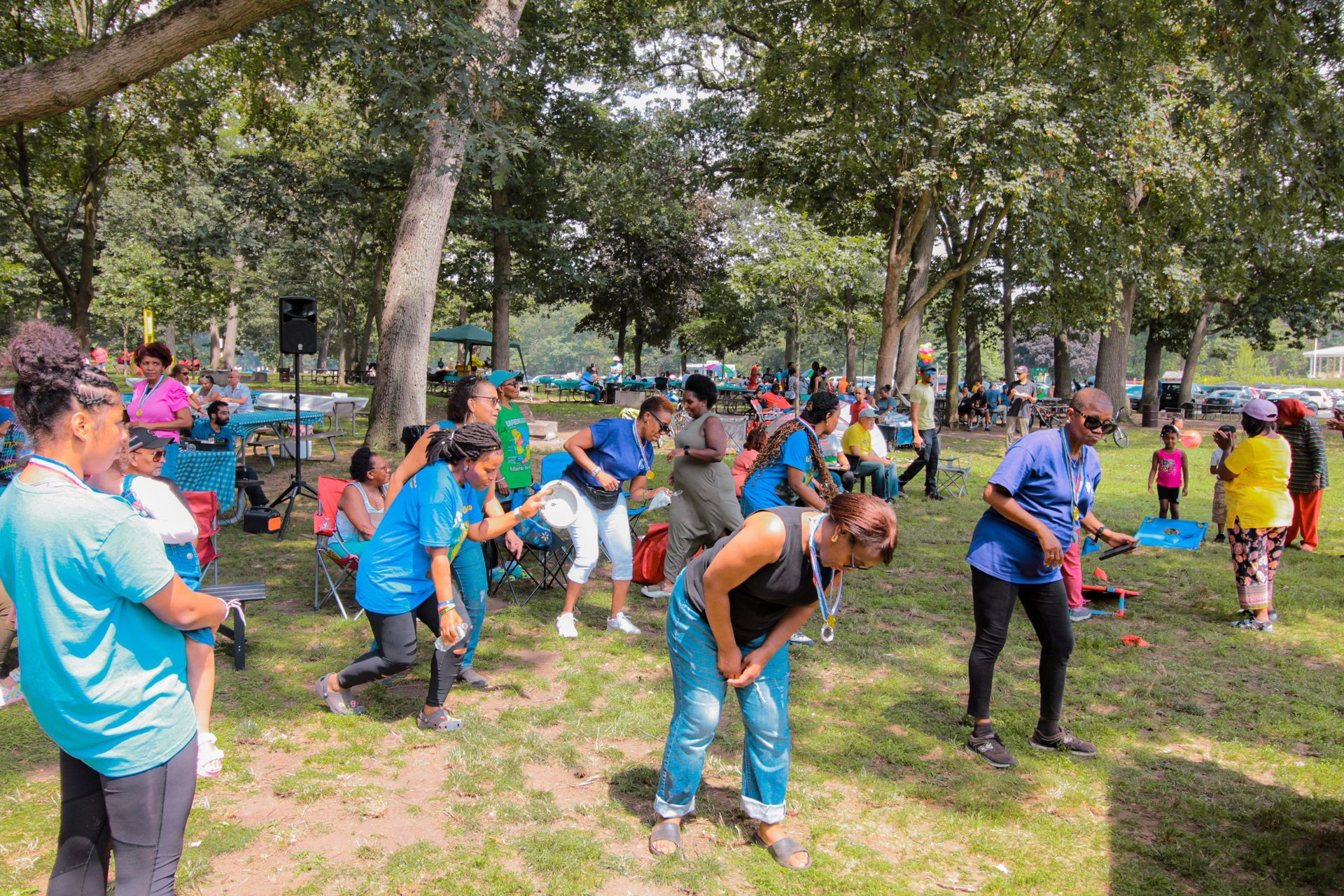 A group of people are dancing in a park.