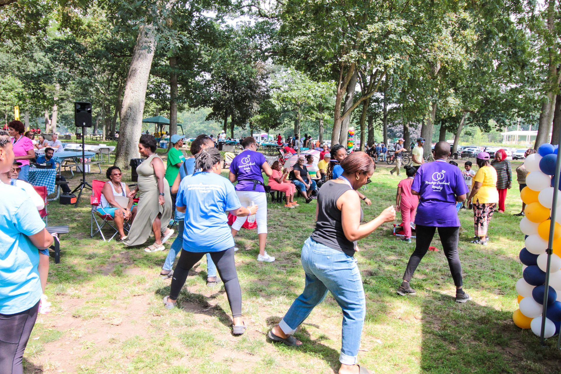 A group of people are dancing in a park.