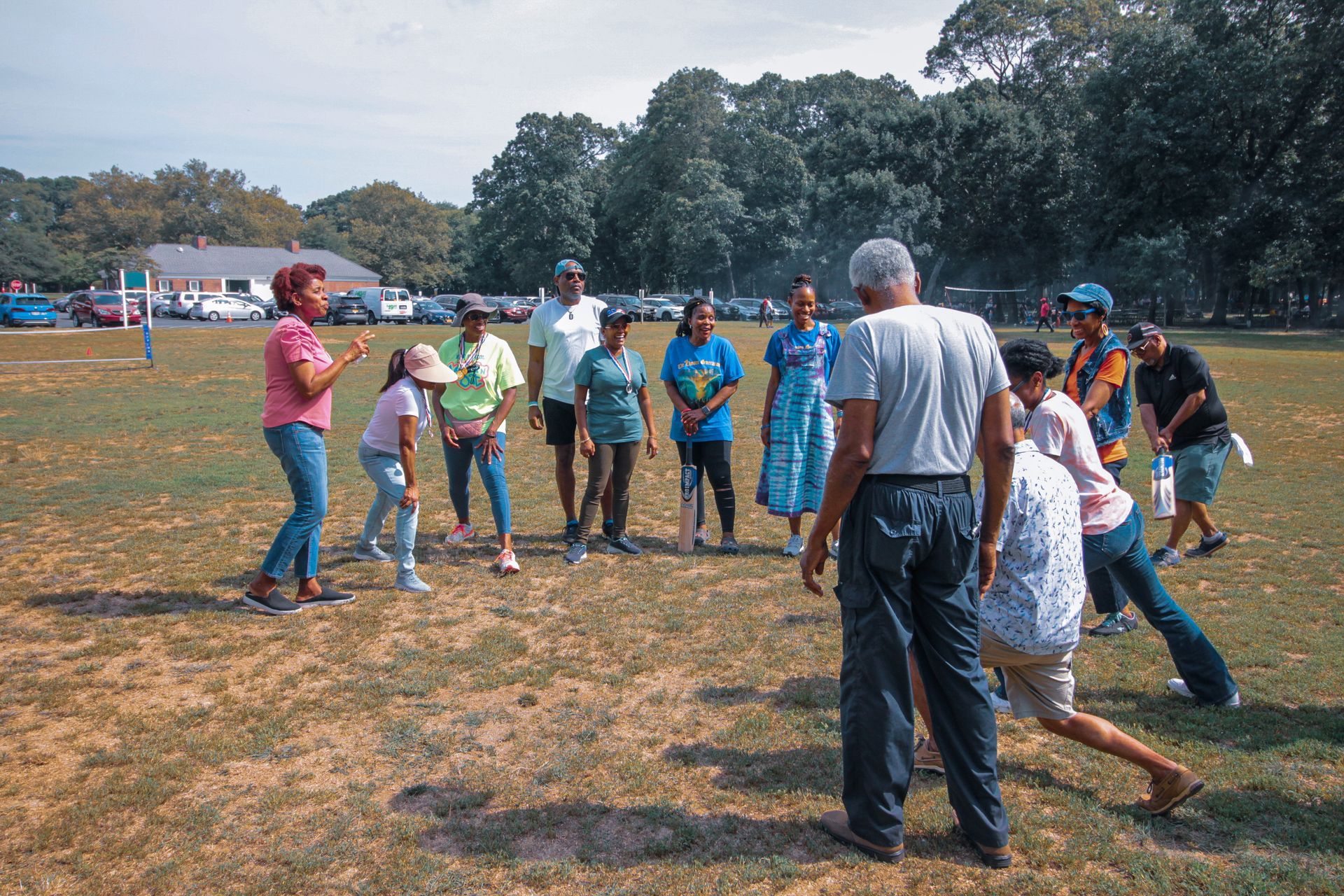 A group of people are standing in a circle in a field.