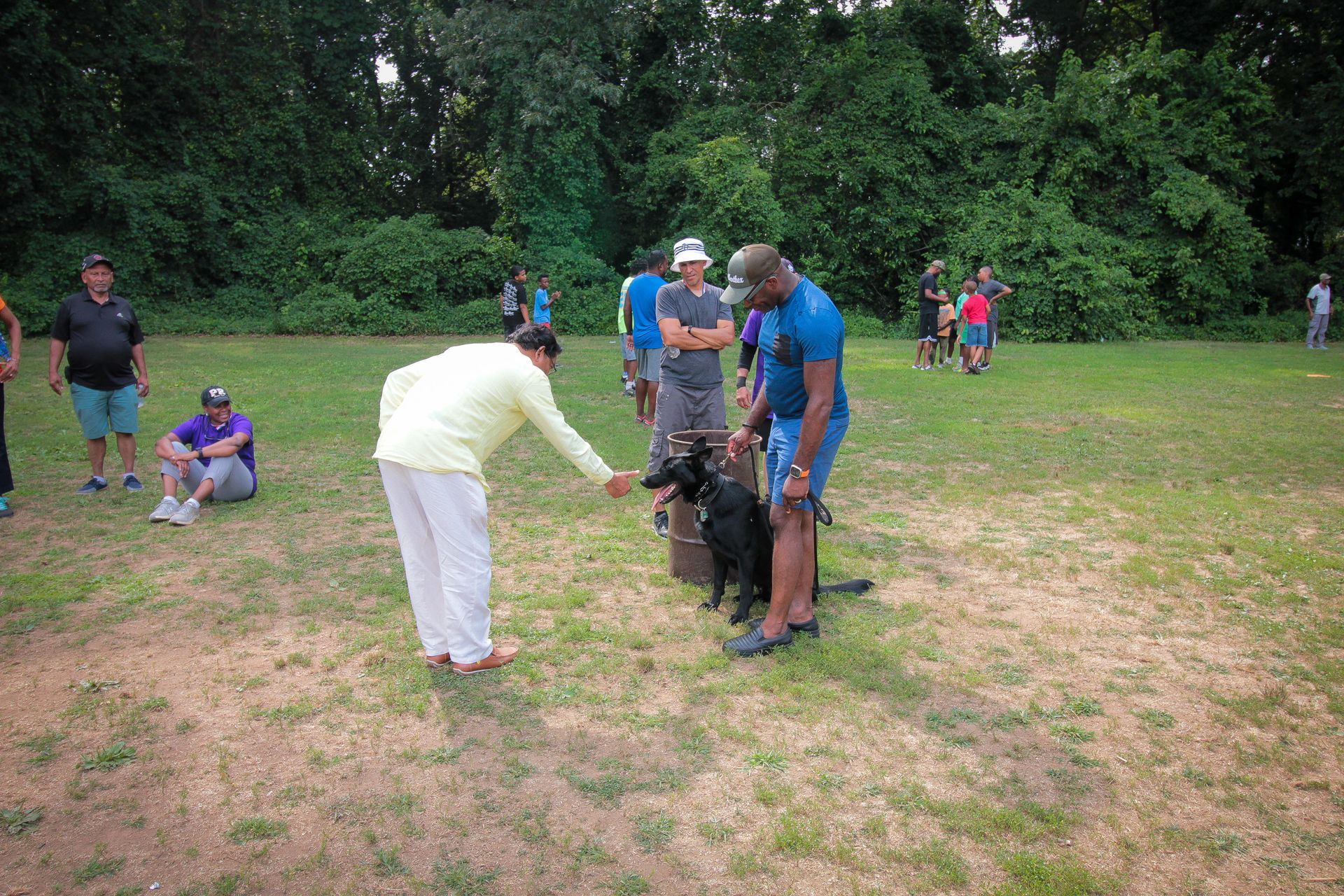 A group of people are standing in a field with a dog.
