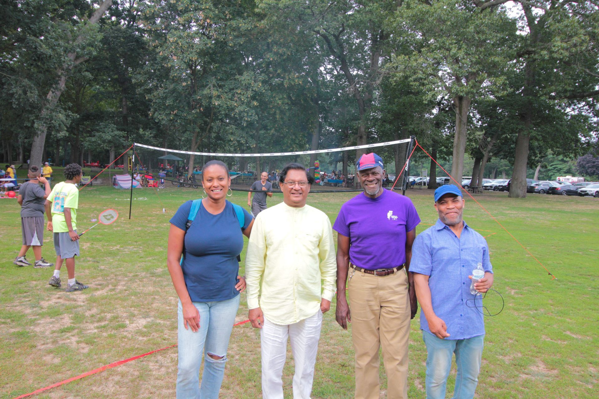 A group of people posing for a picture in front of a volleyball net
