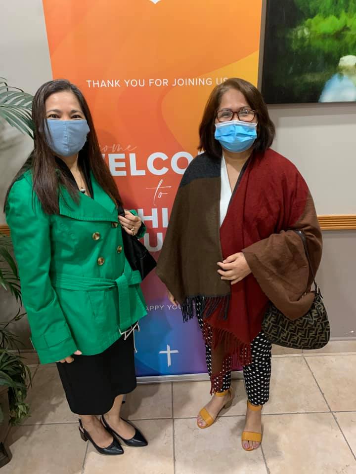 Two women wearing face masks are standing next to each other