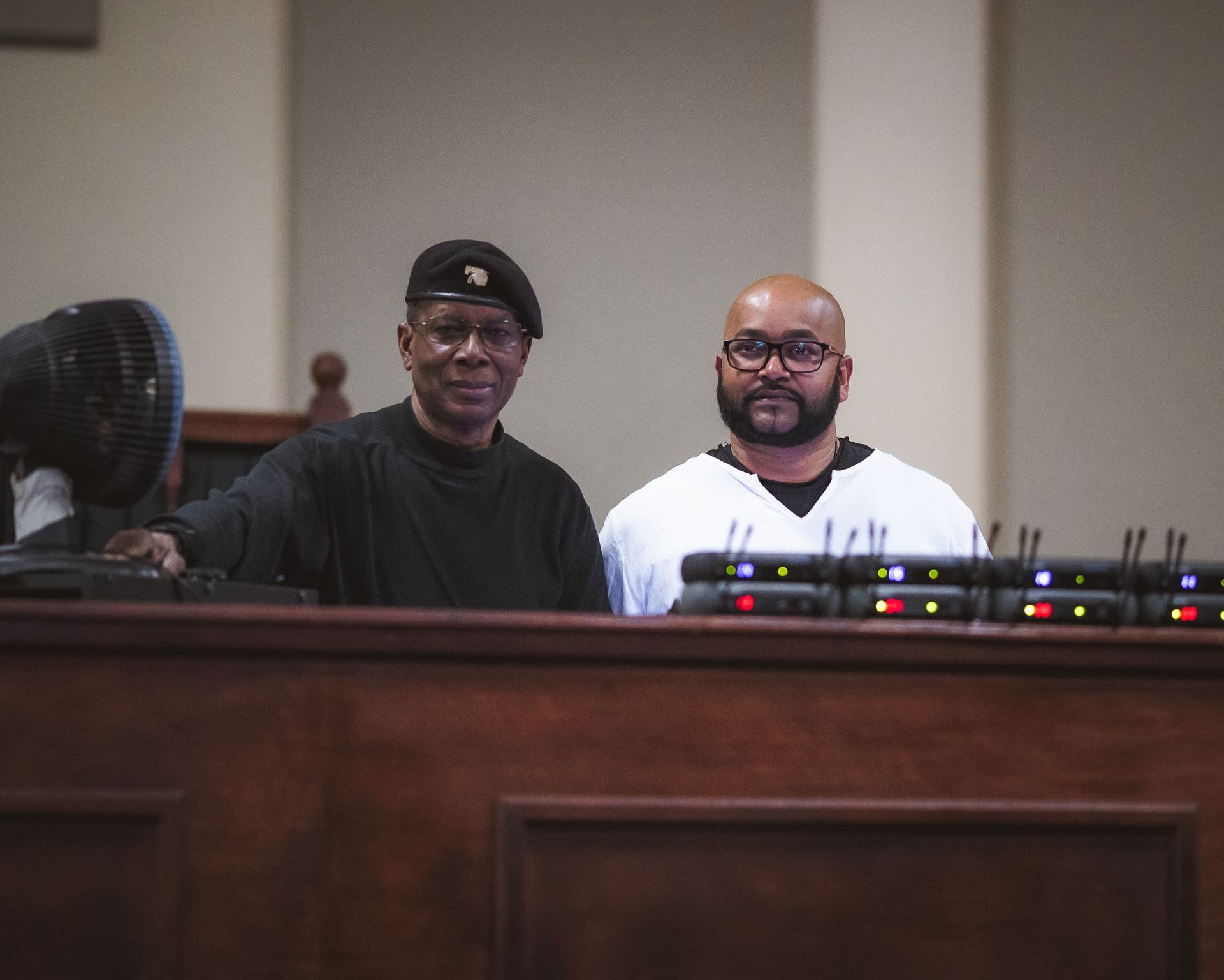 Two men are standing next to each other in a courtroom.