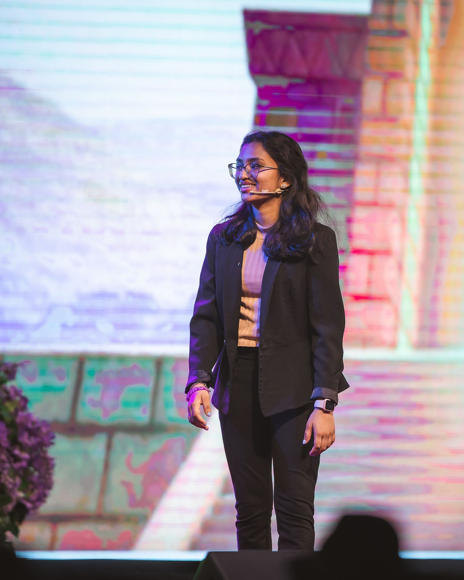 A woman is standing on a stage with a microphone in her mouth.