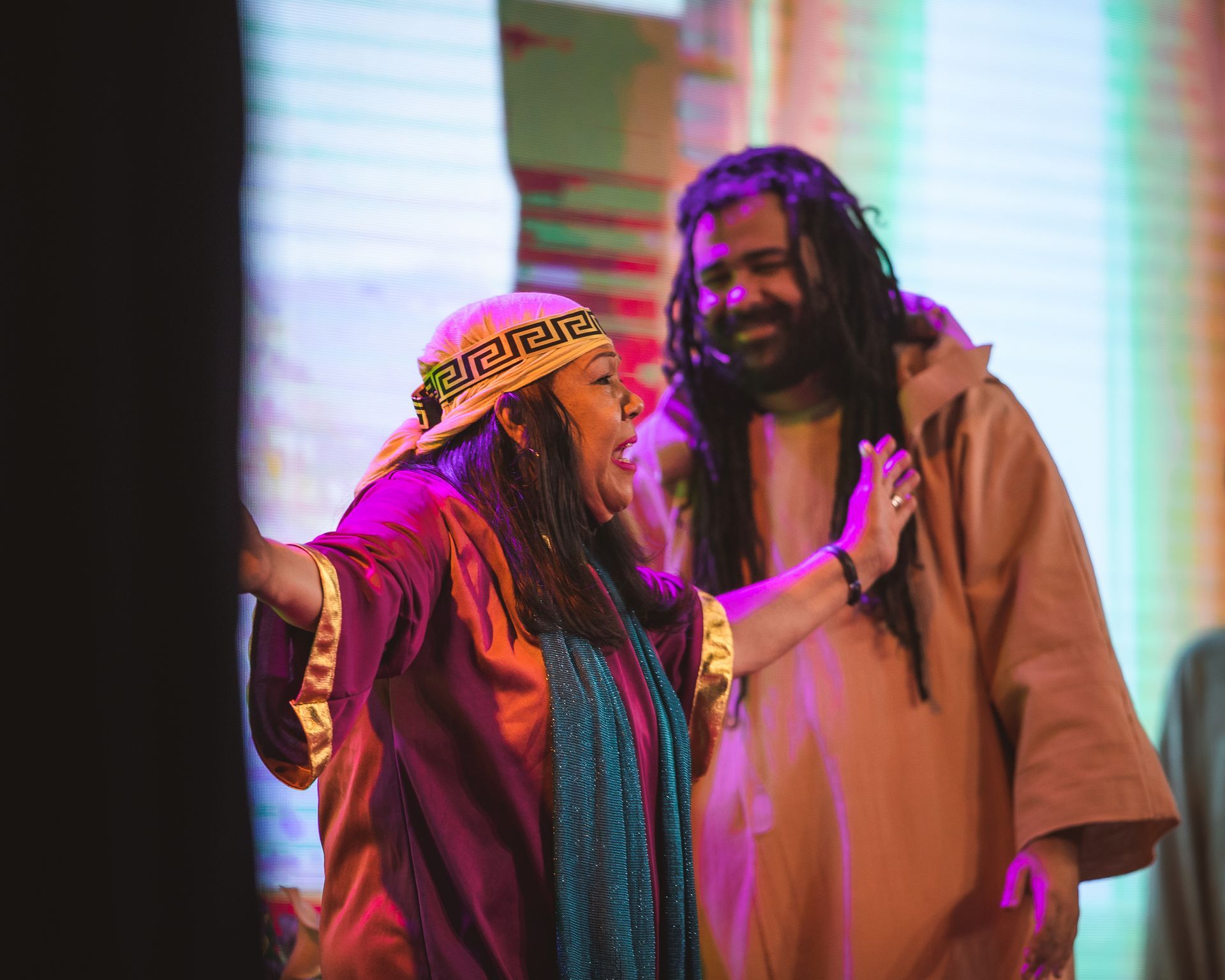A man and a woman are standing next to each other on a stage.