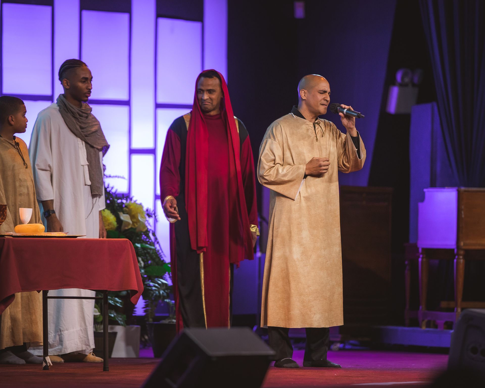 A group of men are standing on a stage singing into microphones