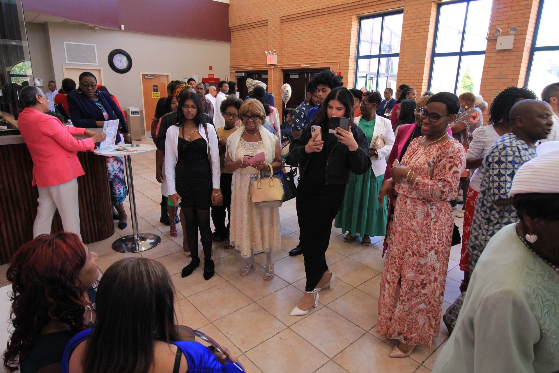 a large group of people are standing in a room .