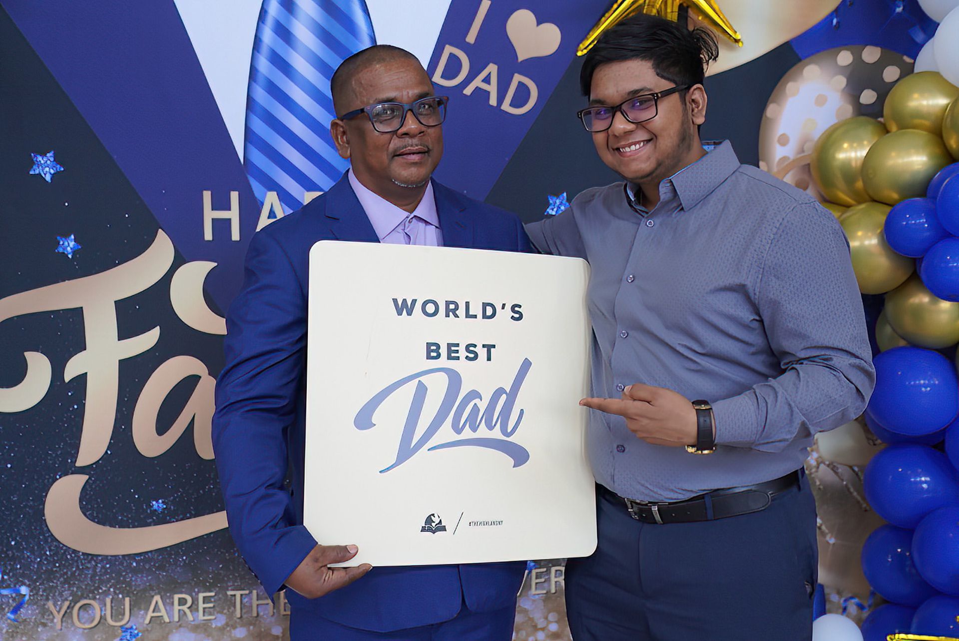 Two men are holding a sign that says world 's best dad