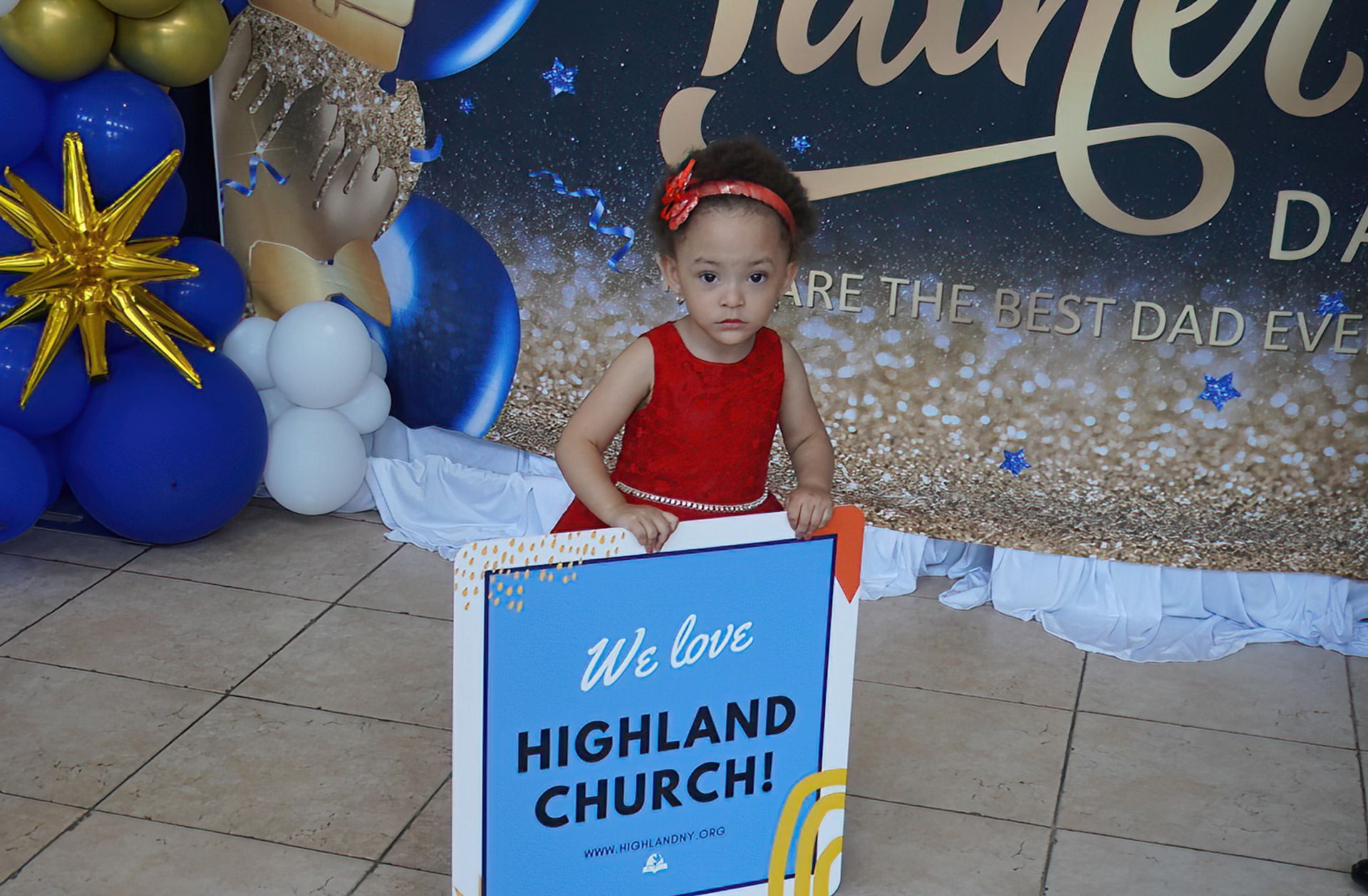 A little girl is holding a sign that says we love highland church