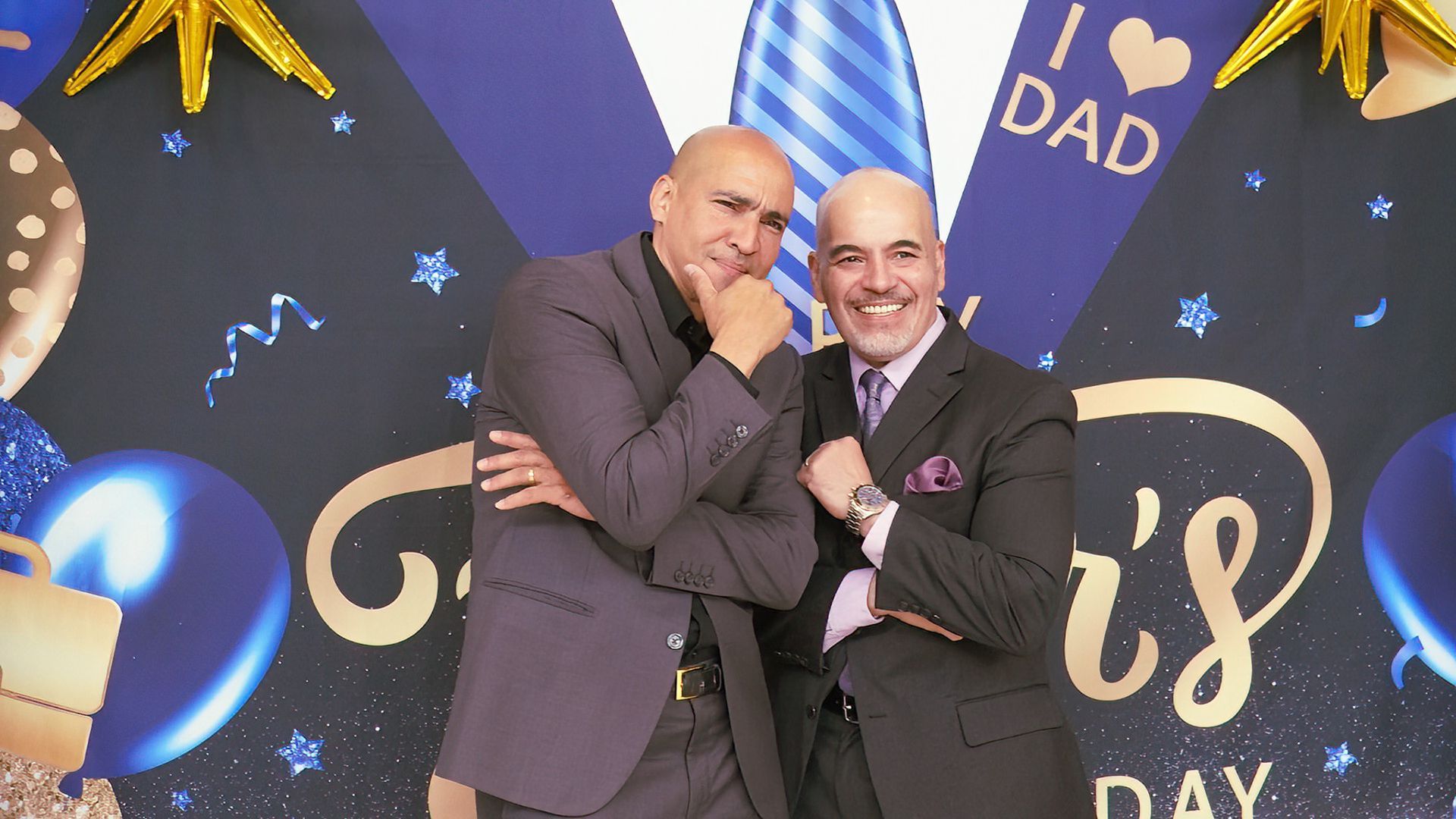 Two men in suits and ties are posing for a picture.