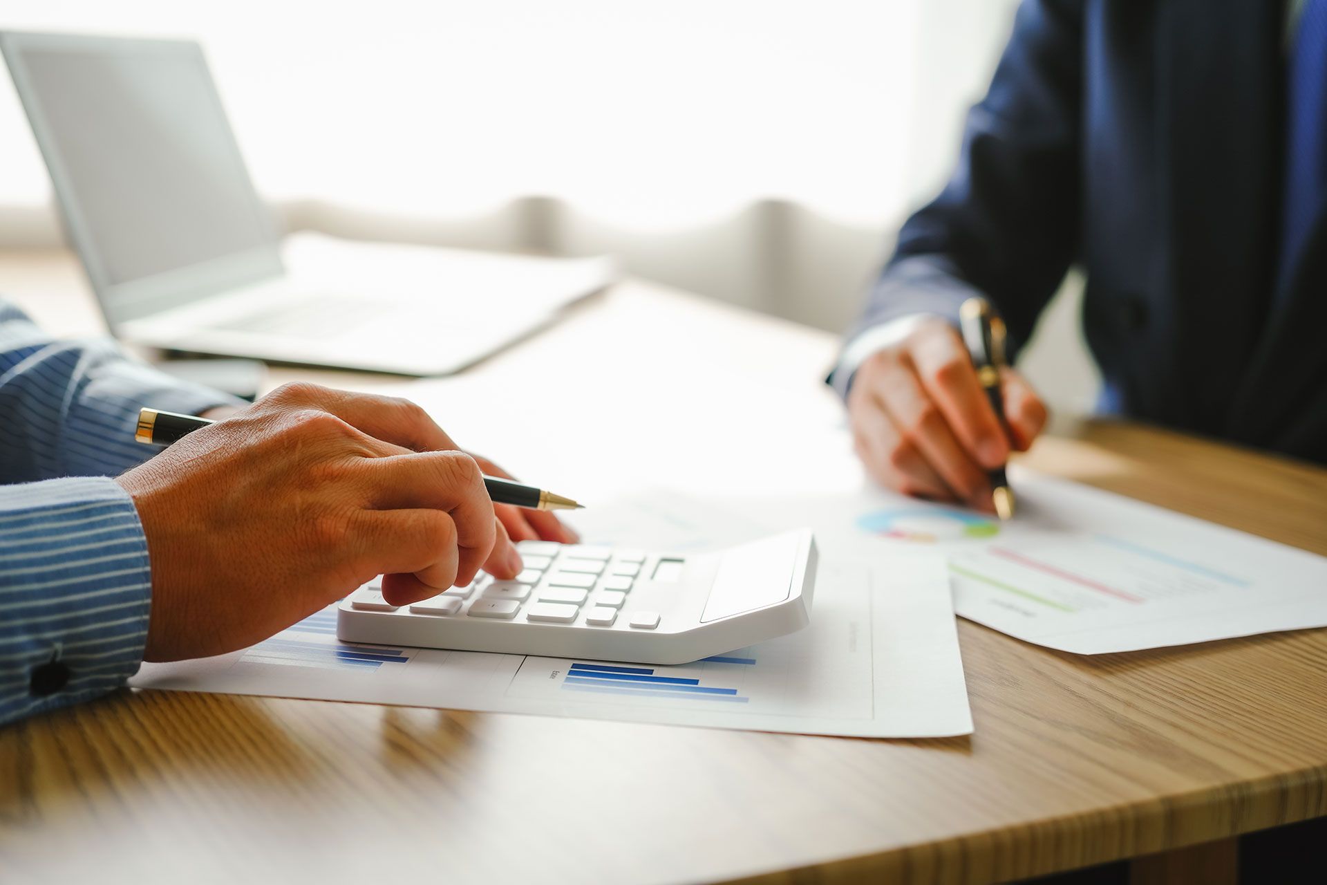 Desk-bound businessman calculates figures, verified accounts, and collaborates in discussions. Proficient in using calculators, aiding each other, and managing annual tax accounts in the audit office