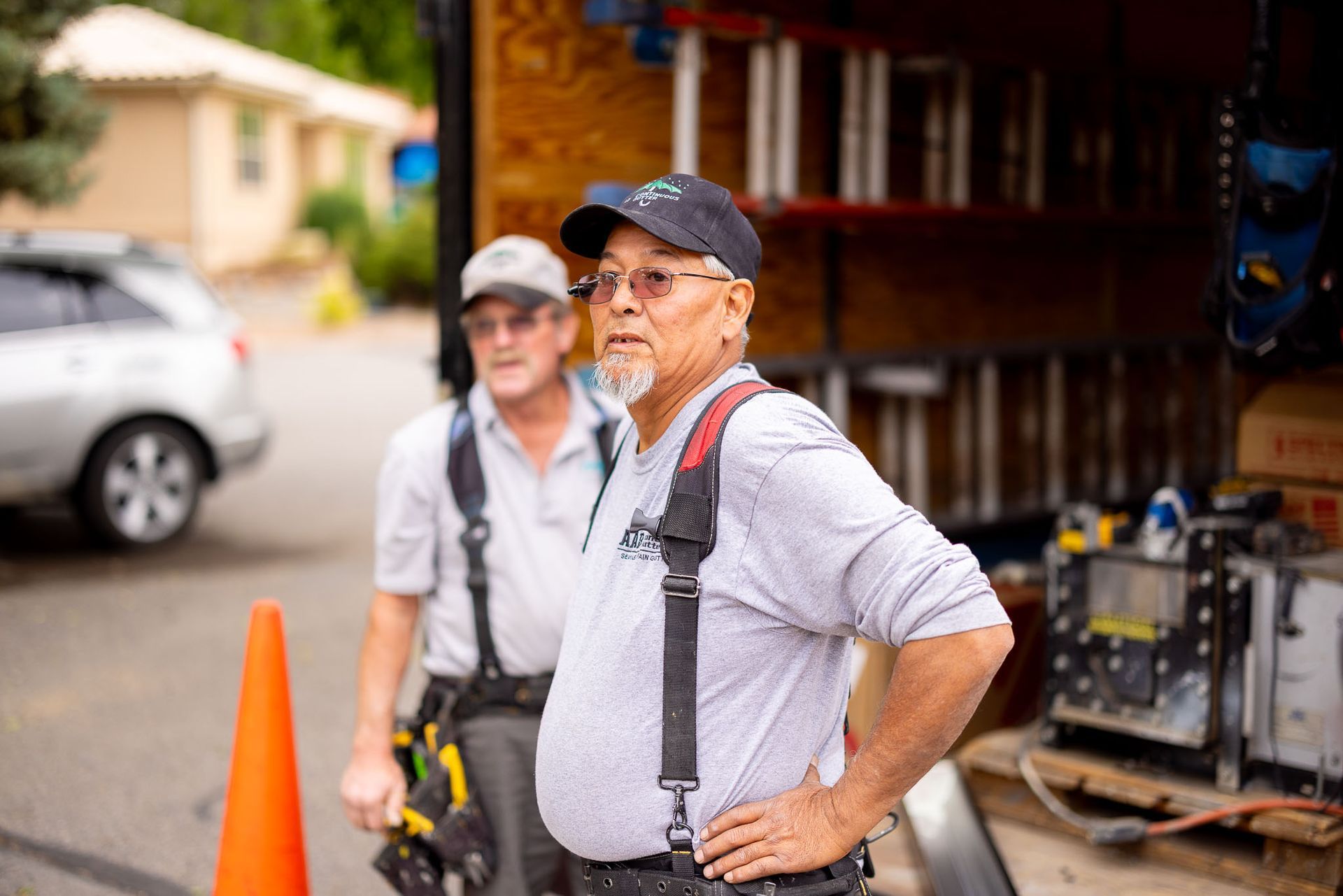 Two men are standing next to each other in front of a truck.