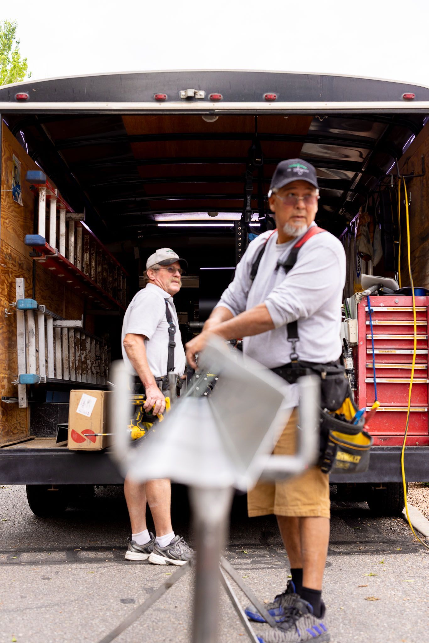Two men are working in the back of a truck.