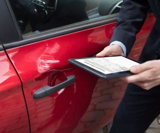 Car Wreck — Man Checking Car Insurance Online Using Tablet in Riverside, CA Car Wreck — Man Checking Car Insurance Online Using Tablet in Riverside, CA