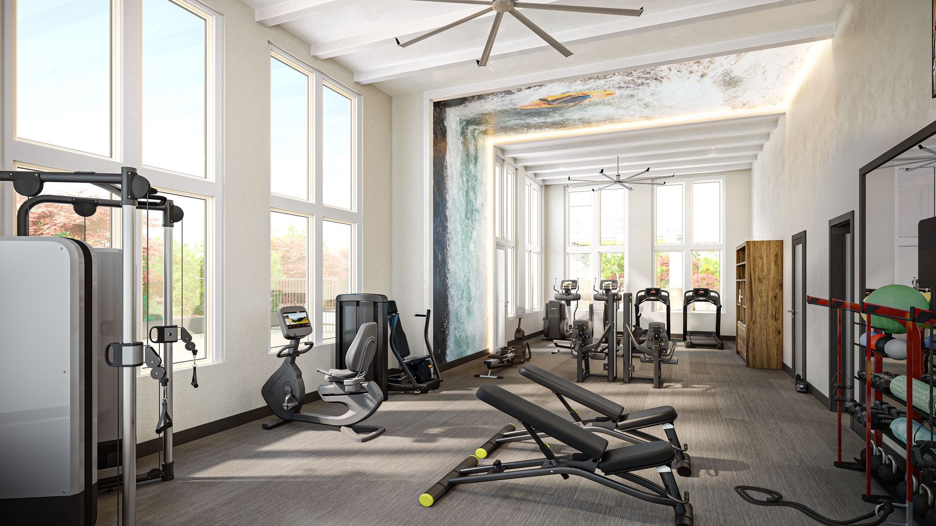 Gym interior with exercise equipment and large windows.