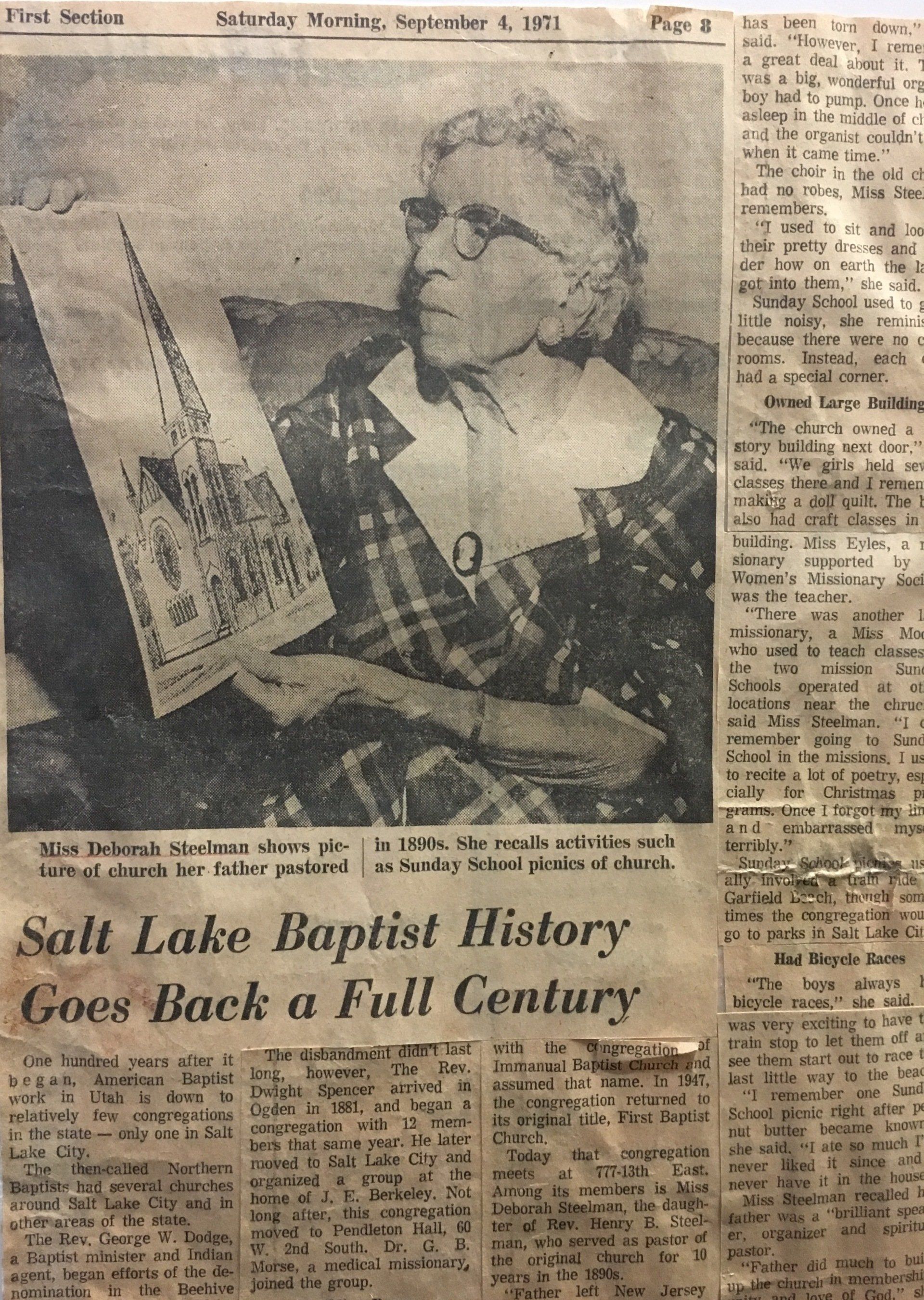 Newspaper clipping: woman holding architectural drawing; headline 