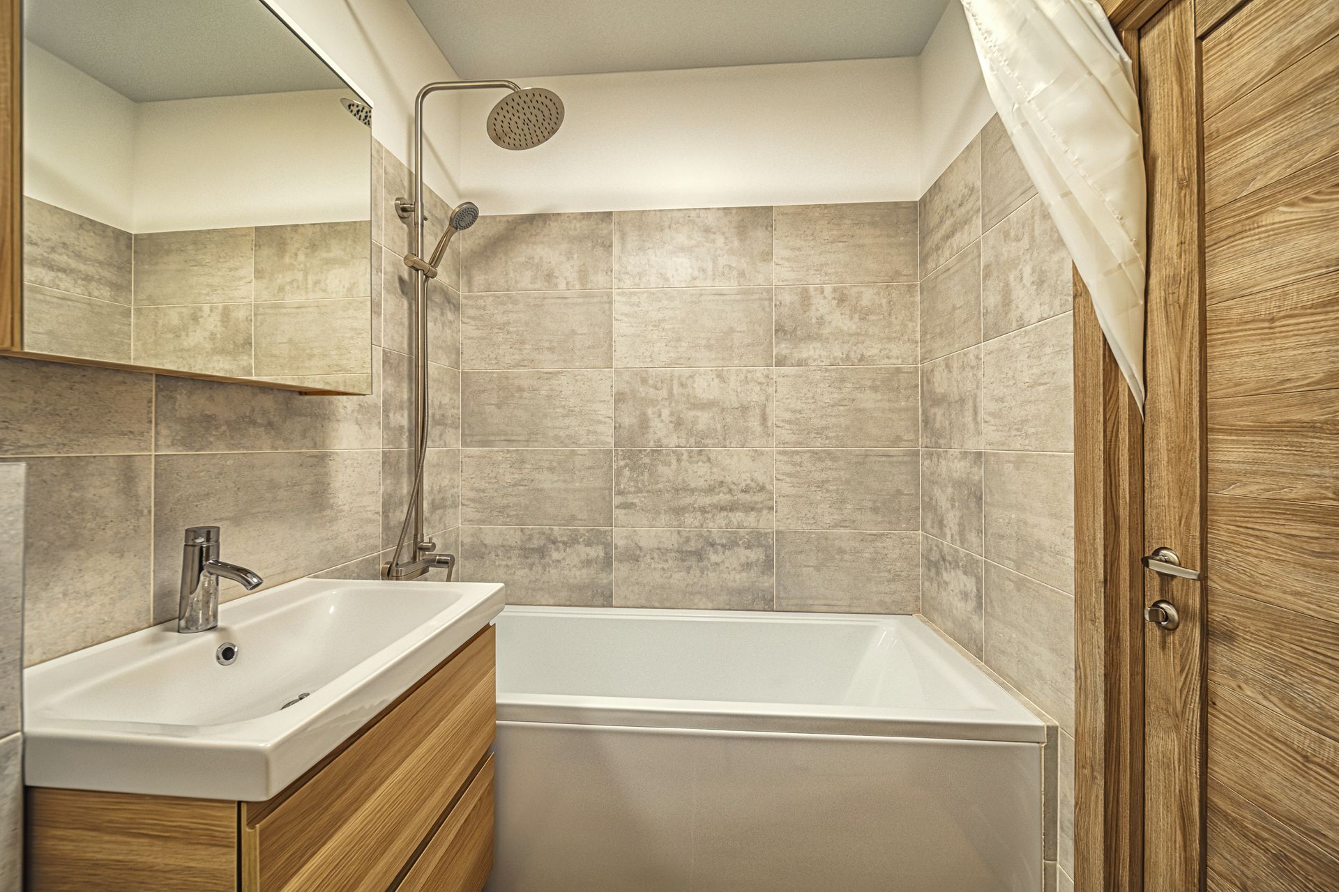 A bathroom with a sink , bathtub , shower and mirror.