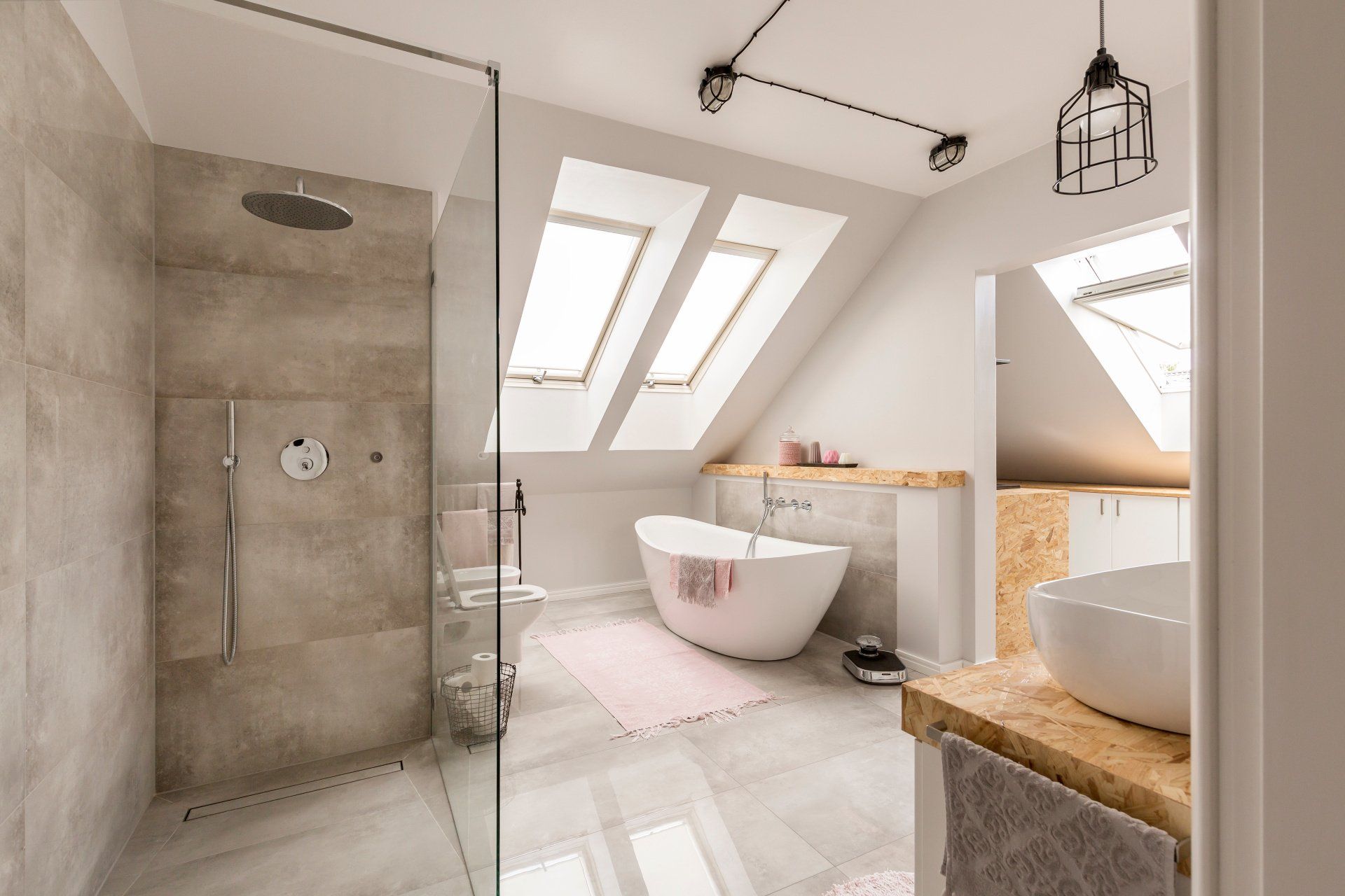 A bathroom with a walk in shower , bathtub , sink and skylights.