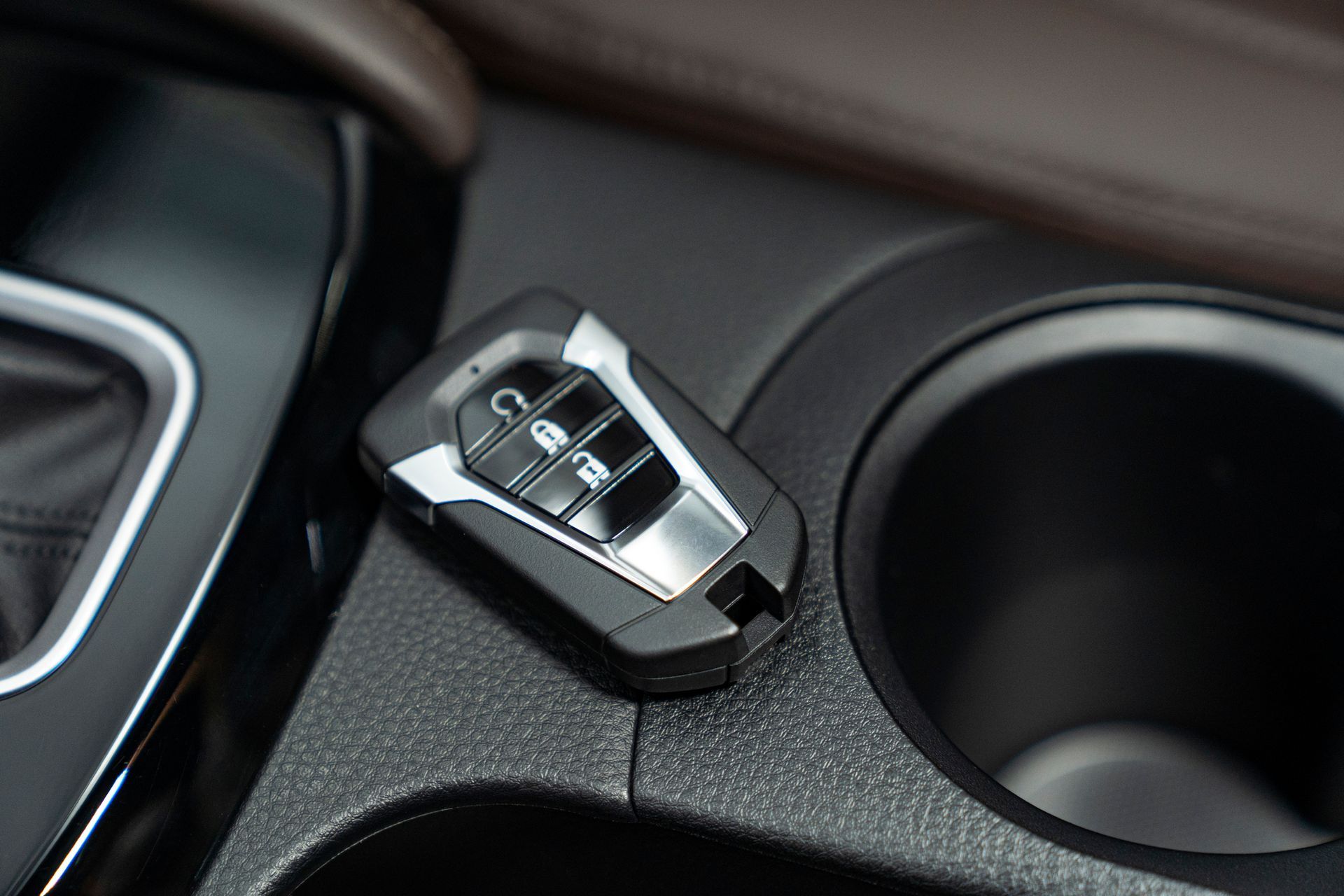 A car key is sitting in a cup holder in a car.