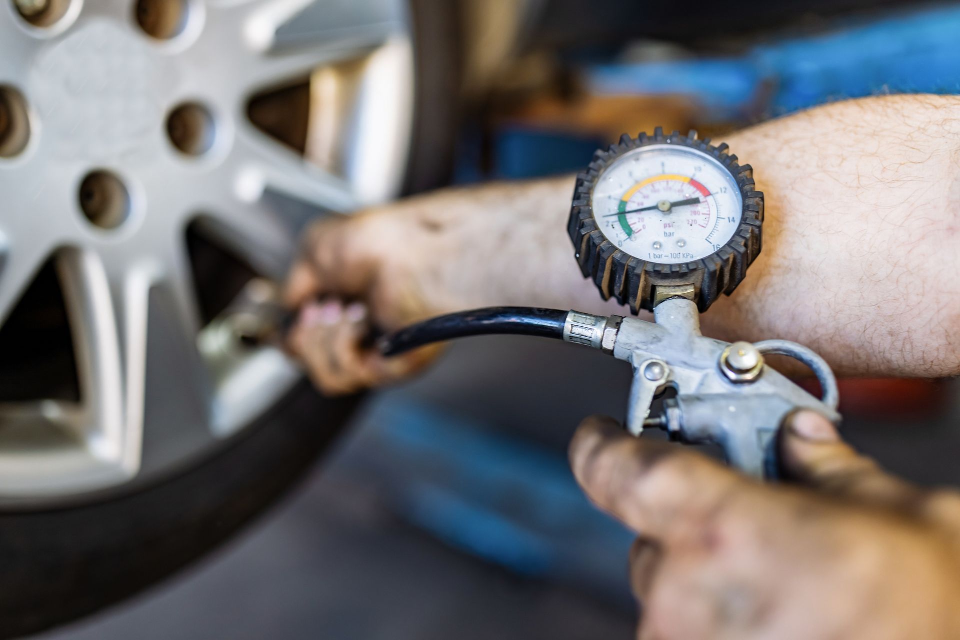 A person is checking the pressure of a tire with a gauge.