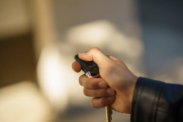 A person is holding a car key in their hand.