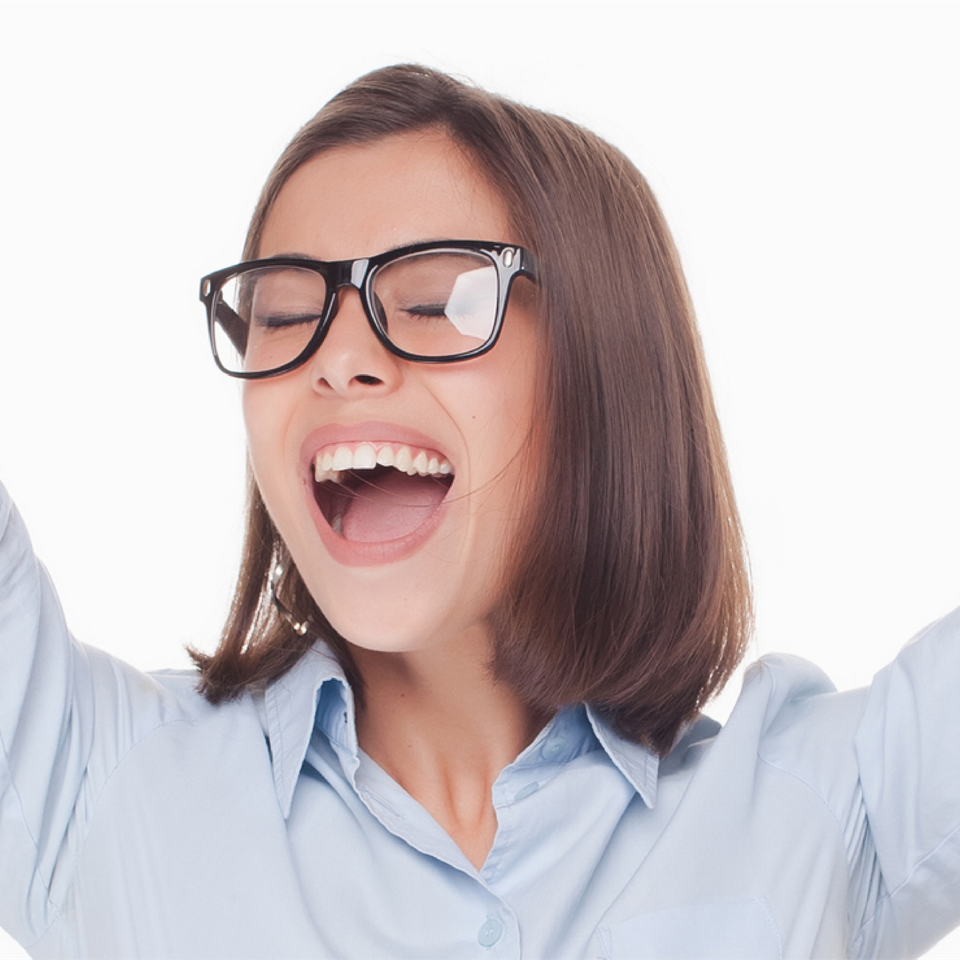 A woman wearing glasses is raising her arms in the air