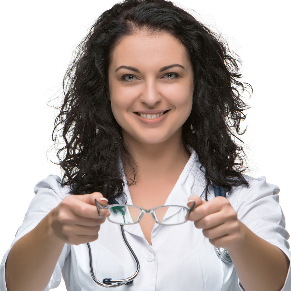 A smiling female doctor is holding a pair of glasses and a stethoscope around her neck