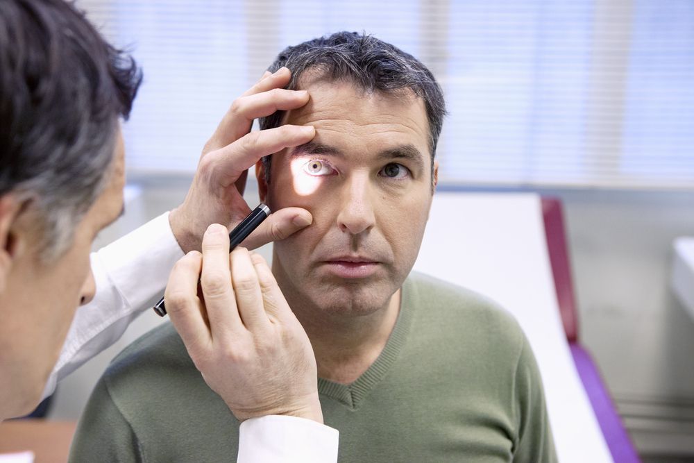 A man is getting his eyes examined by a doctor.