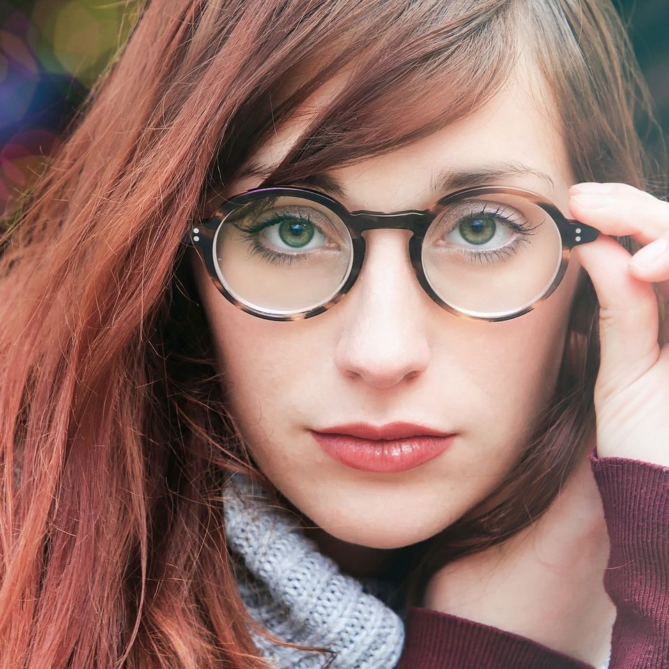 A close up of a woman wearing glasses and a scarf