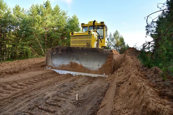 a construction site with a yellow excavator that says cat on it