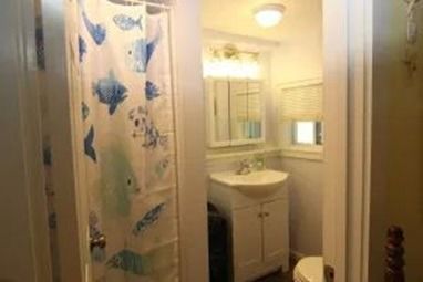 Bathroom with a shower stall, sink, mirror, and cabinet. 