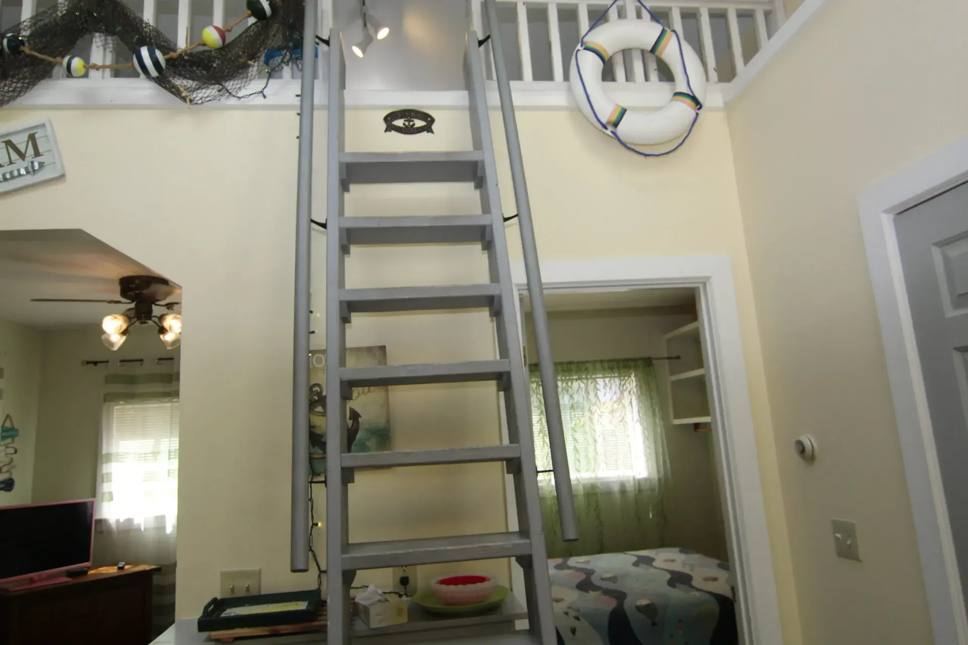 Interior with ladder to loft, decorated in nautical theme.
