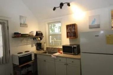 Small kitchen with white cabinets, appliances, and a window.