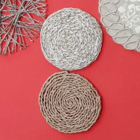 Posavasos de cuerda y tela estampada sobre fondo rojo.