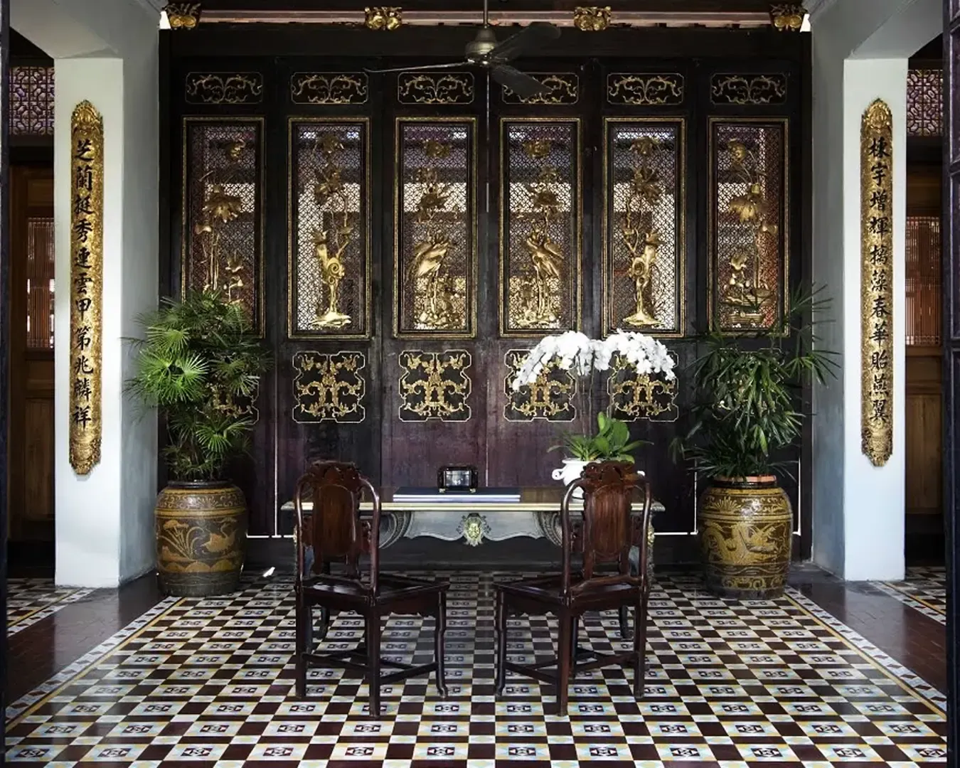 Elegant room with ornate wooden panels featuring gold accents and intricate carvings.