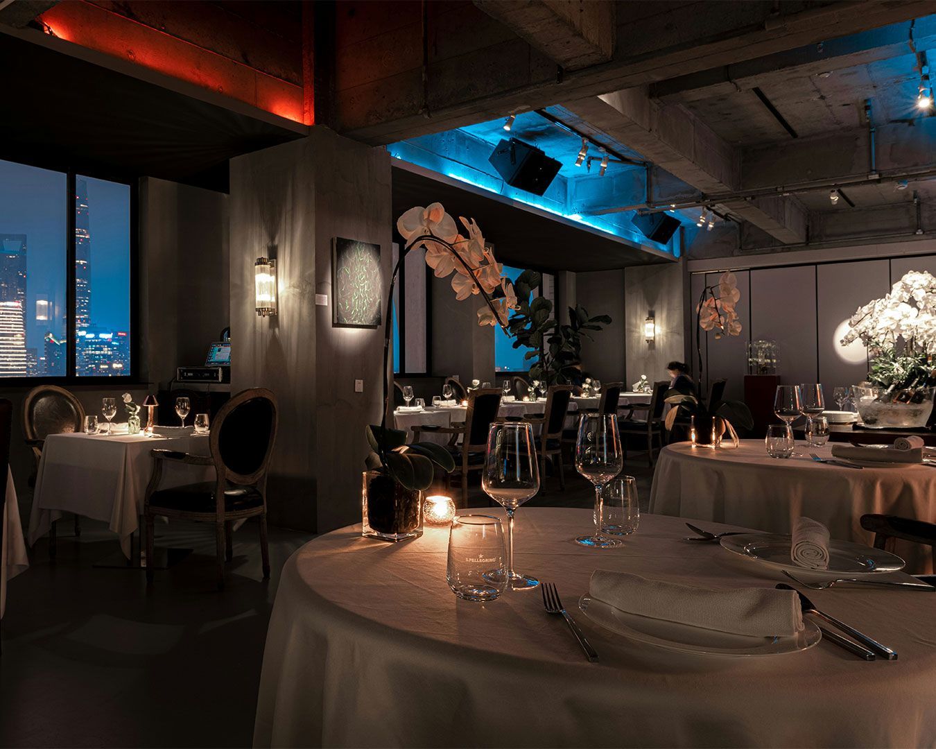 A warm, elegant private dining room with soft lighting, plush seating, and a sophisticated table set