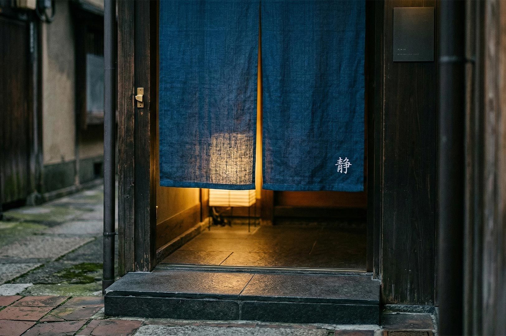 A traditional Japanese restaurant entrance featuring a dark blue linen noren curtain 