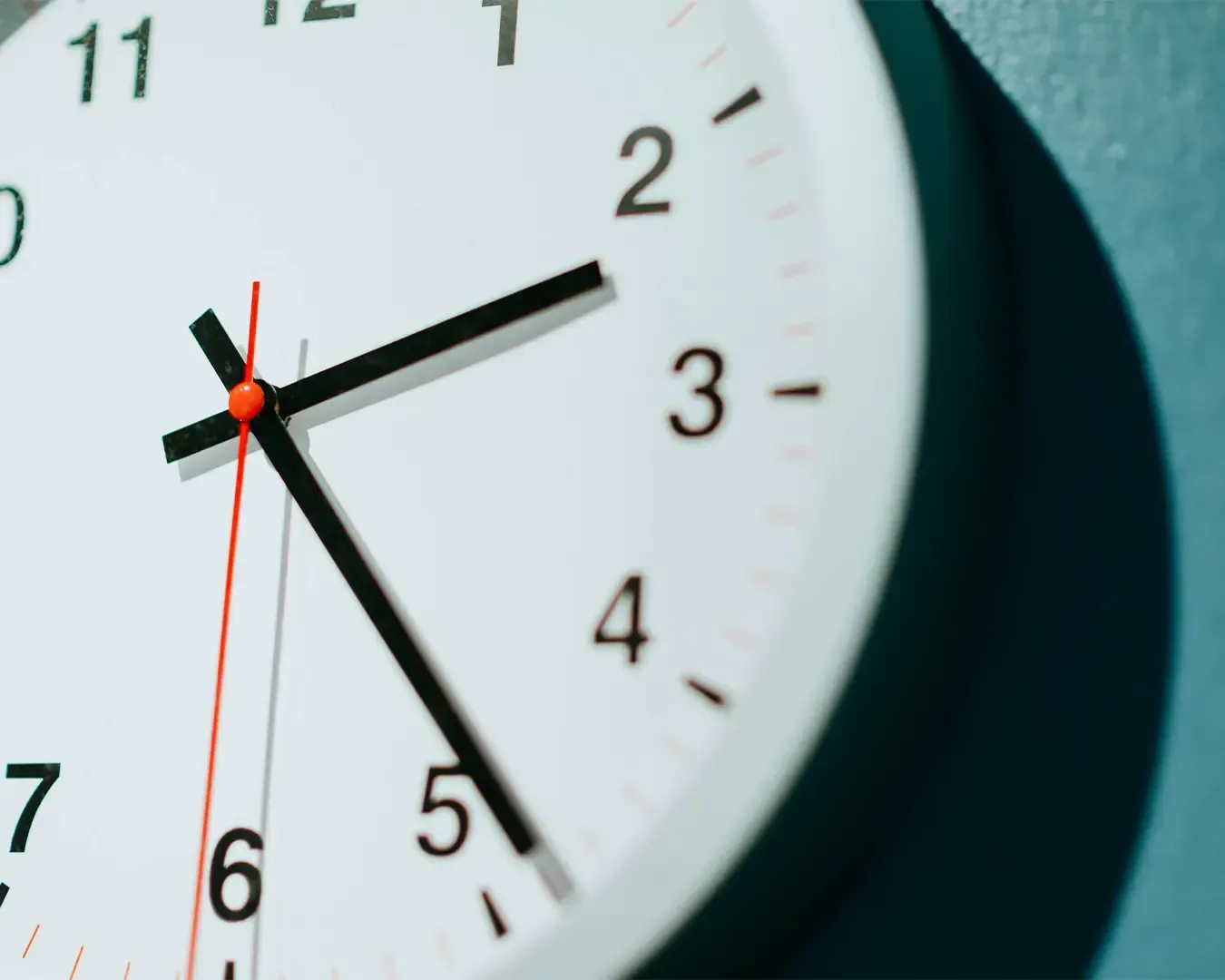 A simple wall clock mounted on a clean interior wall, its hands clearly marking the time.