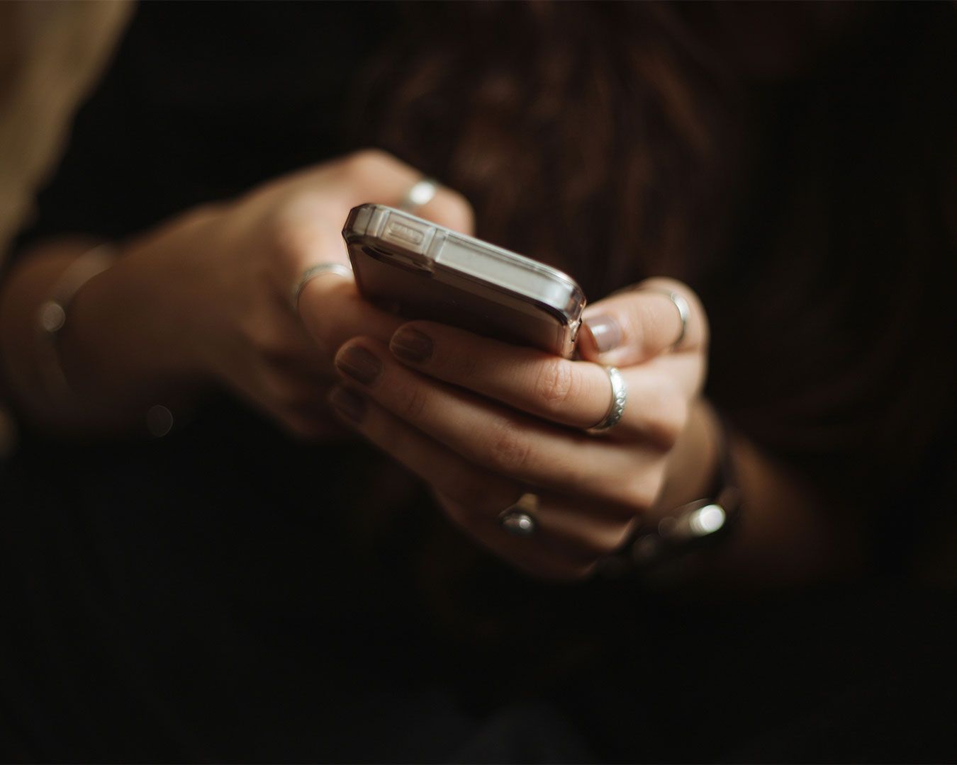 A hand holding a smartphone, capturing a photo or checking content, set against a blurred, modern background for a lifestyle or tech-focused scene.