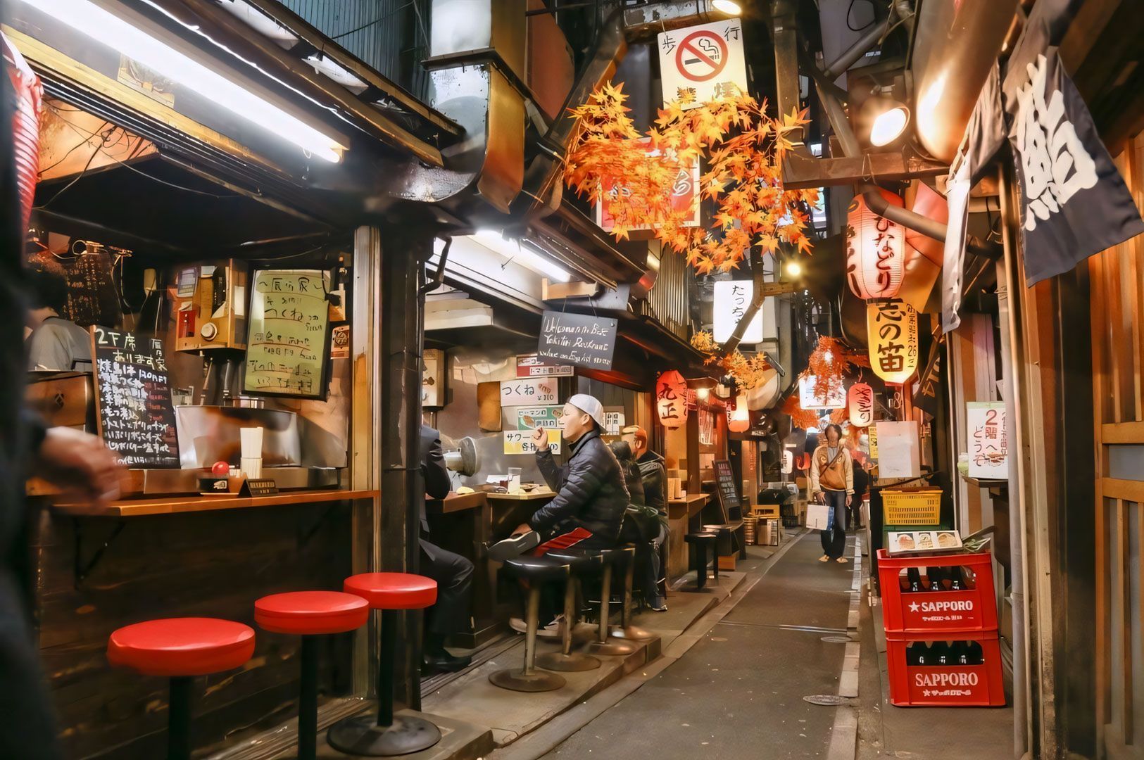 A view down the narrow, atmospheric alley of Shinjuku's Golden Gai in Tokyo at night, showing small, cluttered bars and restaurants lit by lanterns and neon signs.