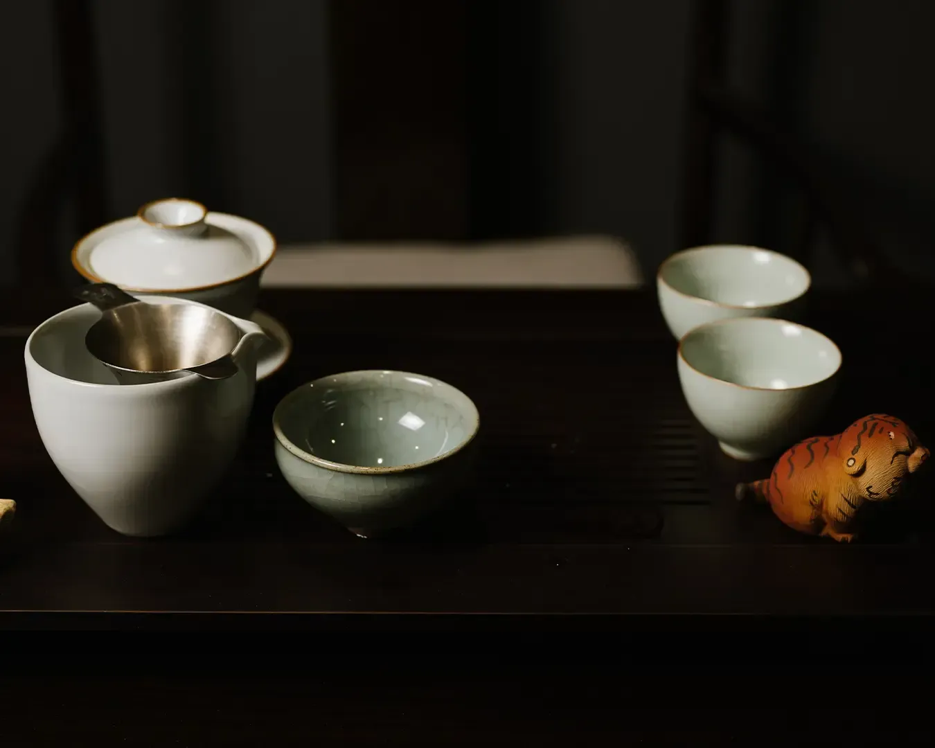 A complete Chinese tea set arranged on a wooden tea table, including small teacups, prepared for a traditional tea tasting experience.